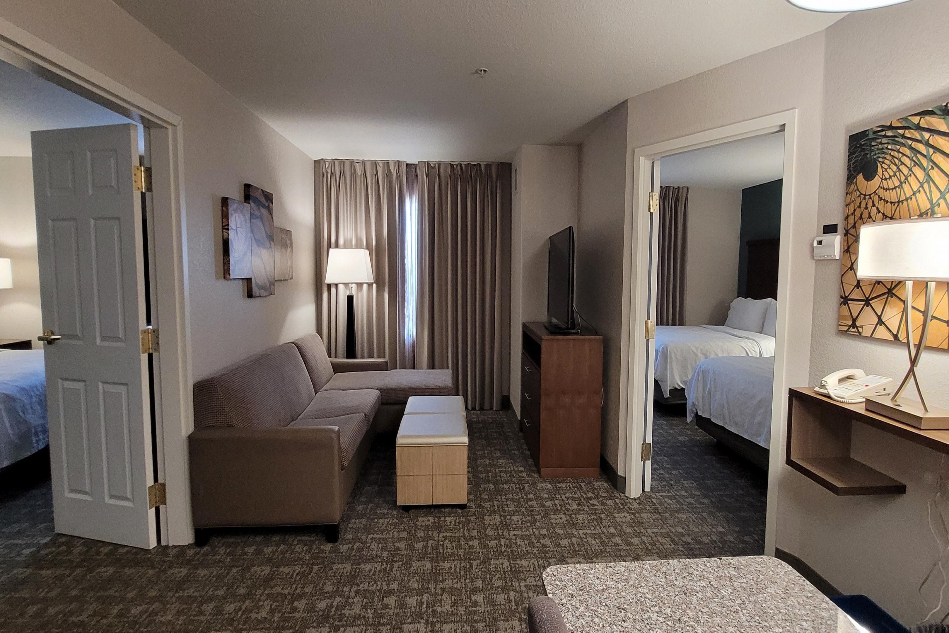 Experience ultimate comfort in our spacious two-bedroom suite, featuring one king bed and two queen beds. Enjoy the privacy of two master bedrooms, each with its own bathroom, a separate living area, a full kitchen, and a cozy twin-size pull-out sofa bed. Come and indulge in comfort at our hotel.