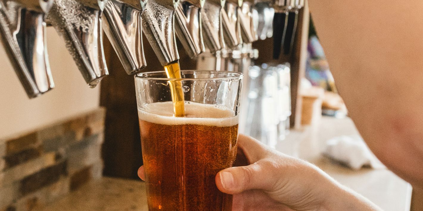 Glass of beer being poured at local brewery