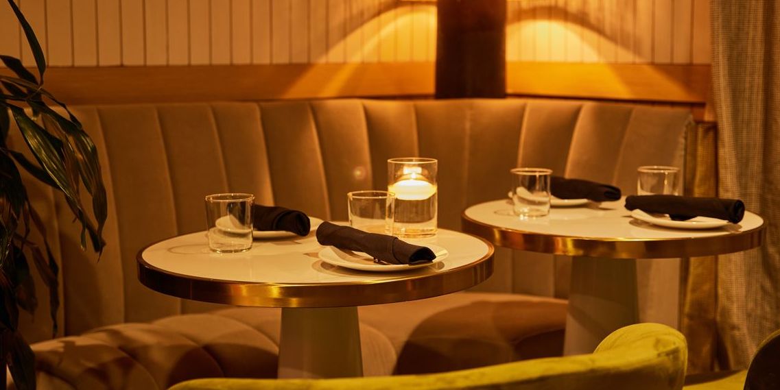 Two dining room tables featuring soft lighting