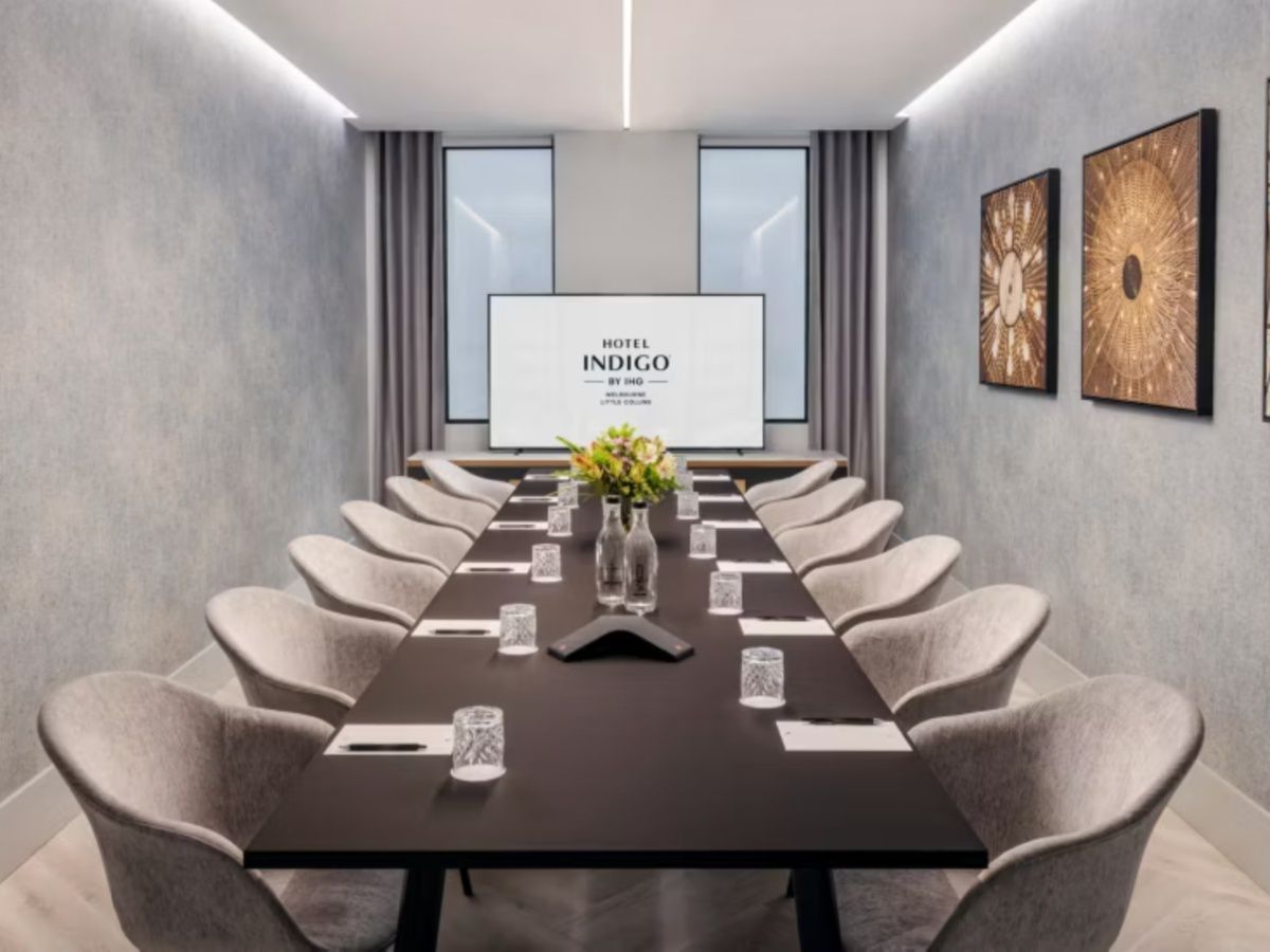 Modern boardroom with conference table and presentation screen