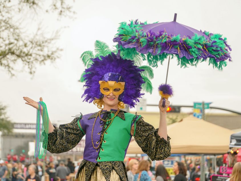 Participant dressed up in Mardi Gras attire at Thomas Park