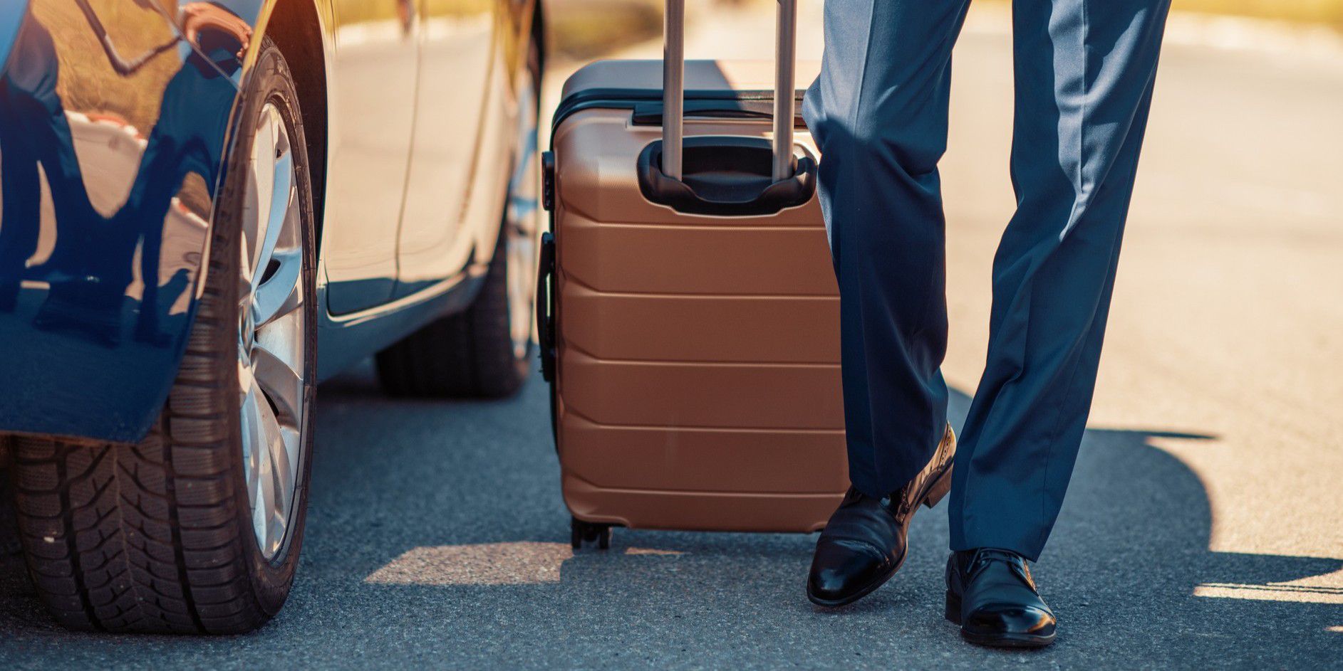 Traveler walking by car with luggage