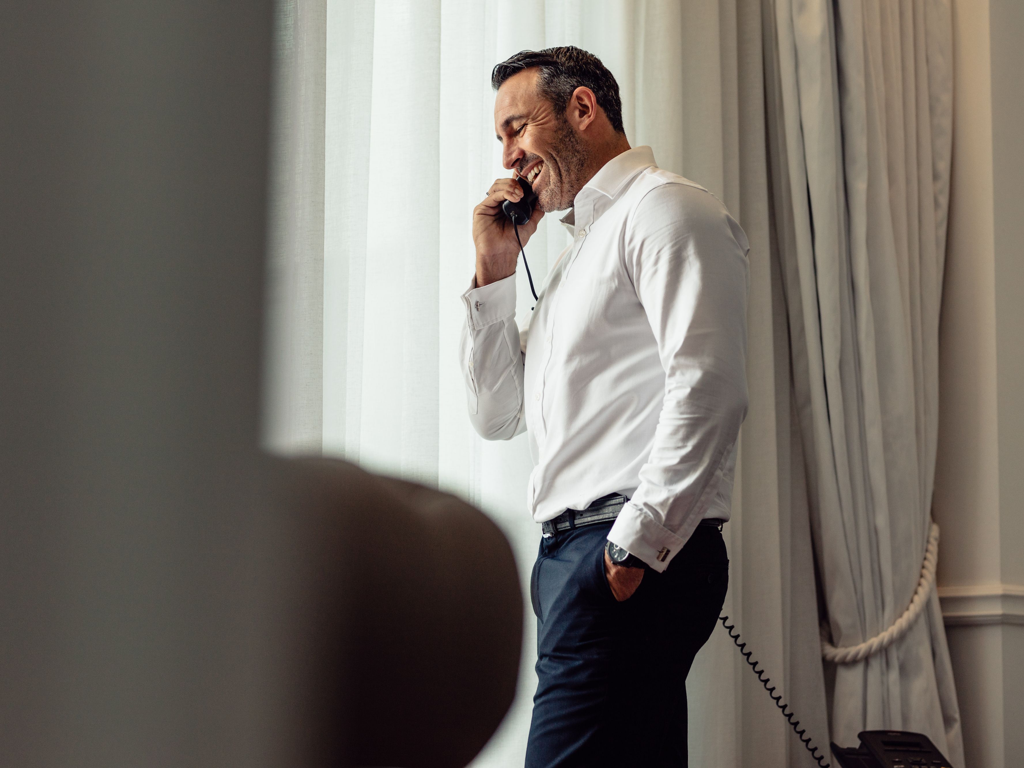 Man talking on the phone in a hotel room.
