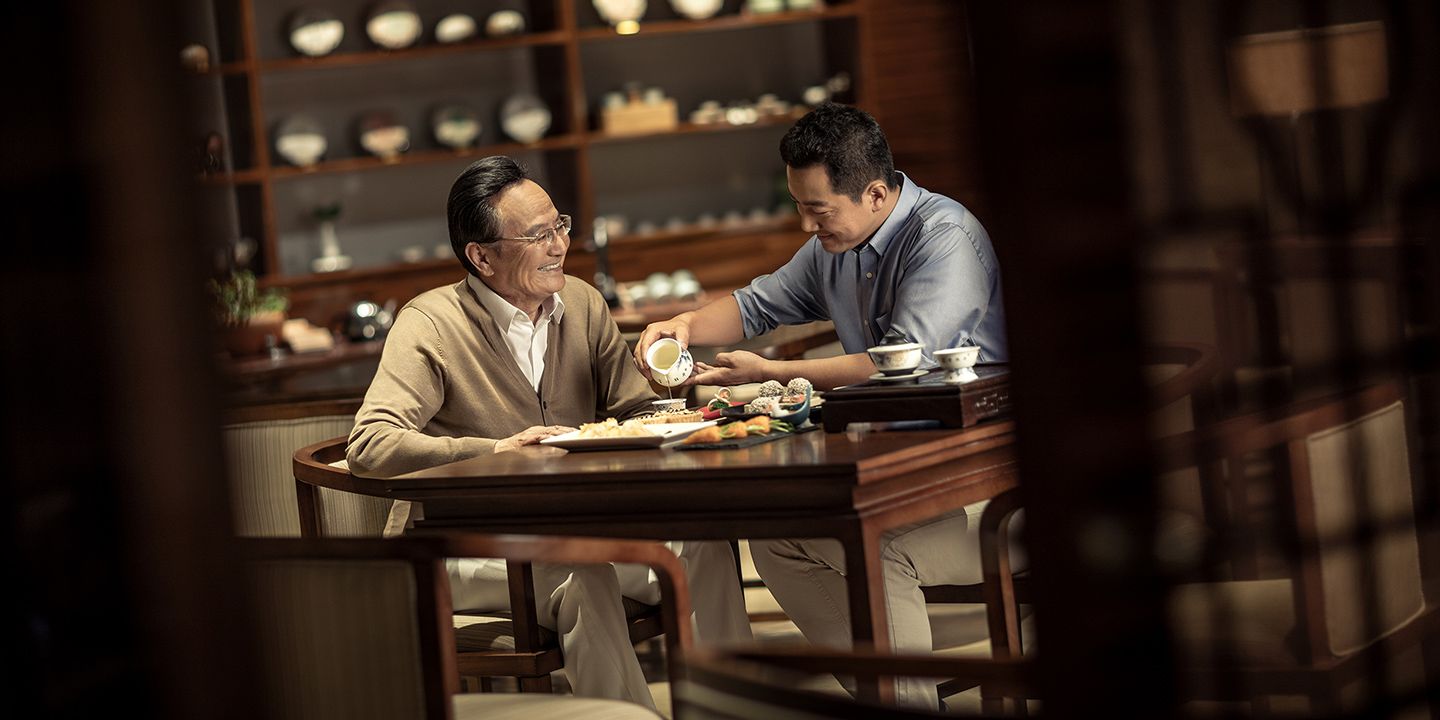 Man pouring tea for another man