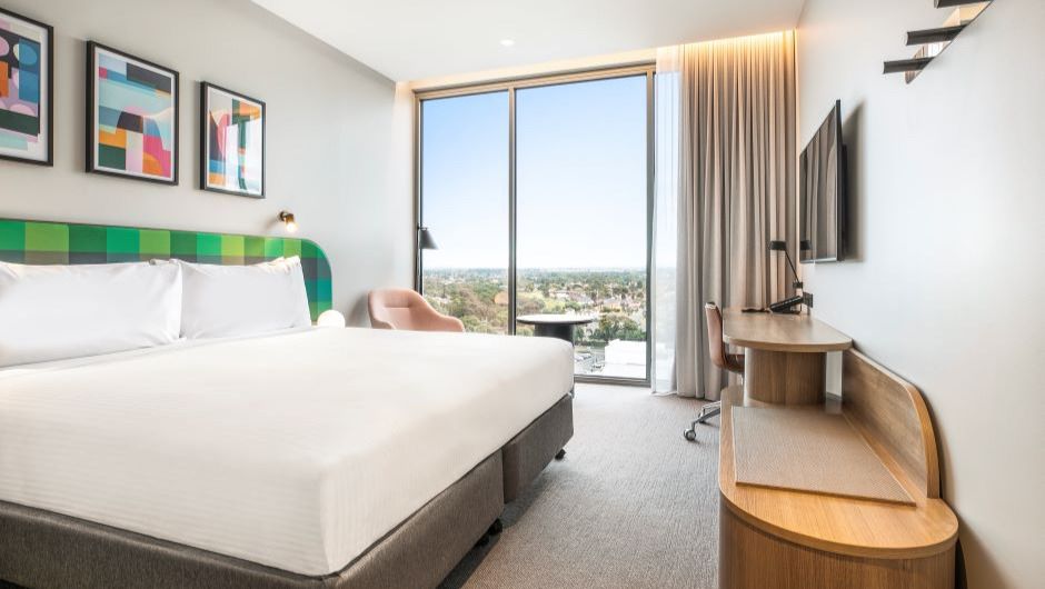 Bedroom with a long panel glass window at Holiday Inn Werribee
