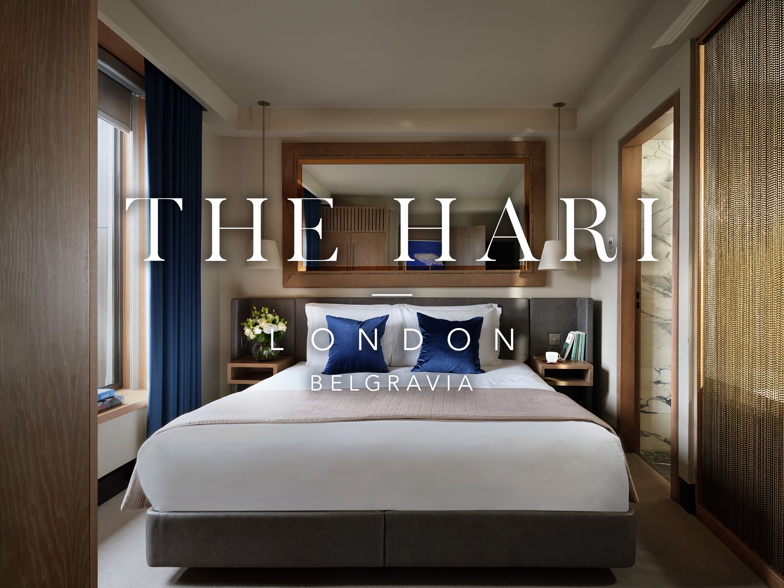 Hotel guest room with "The Hari London" logo on top.