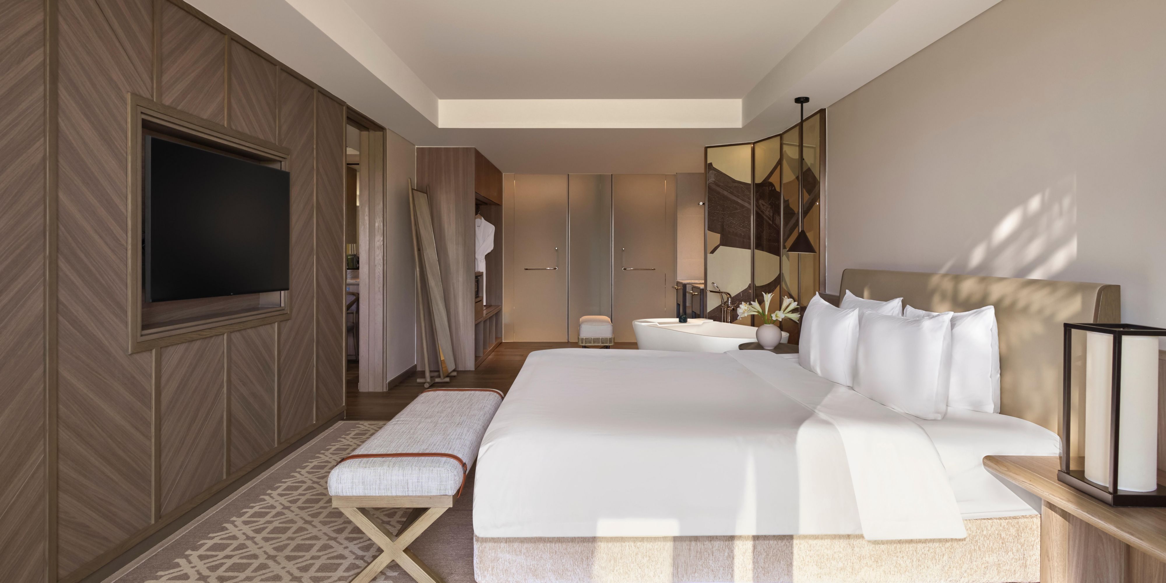 Suite bedroom bathed in natural light with refined, calming design