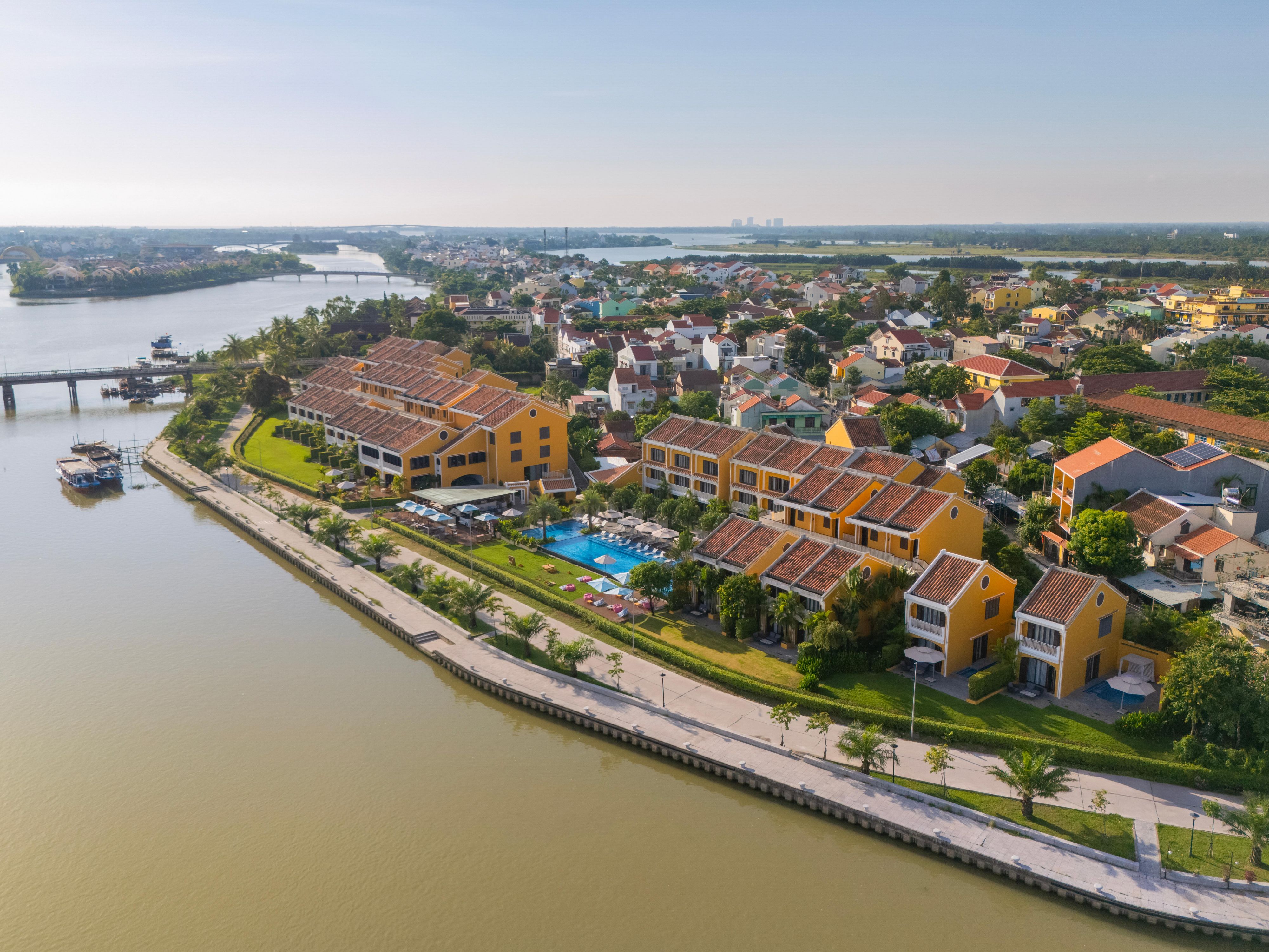 Riverside serenity at Moire Hoi An, framed by vibrant rooftops.   