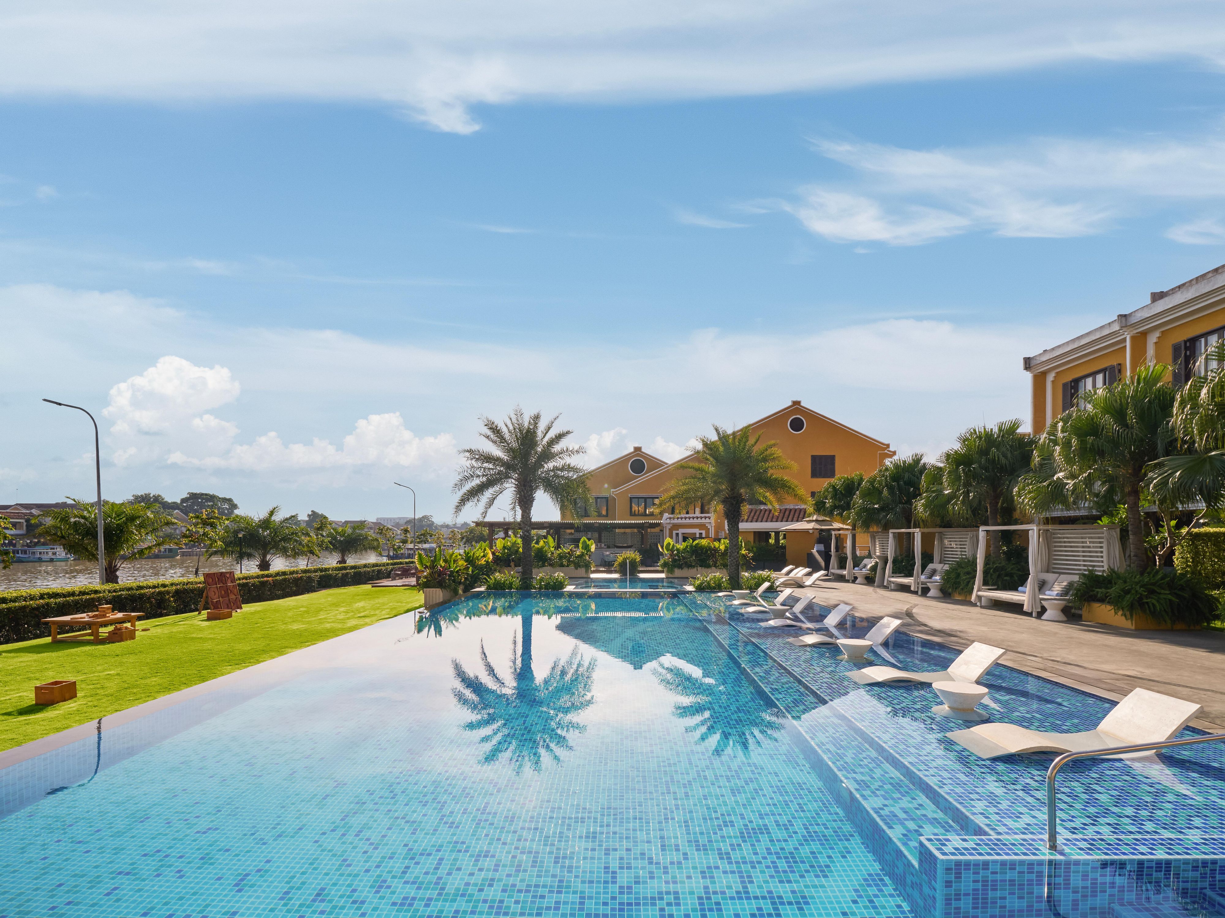 Serene poolside retreat with river views and tropical charm.      