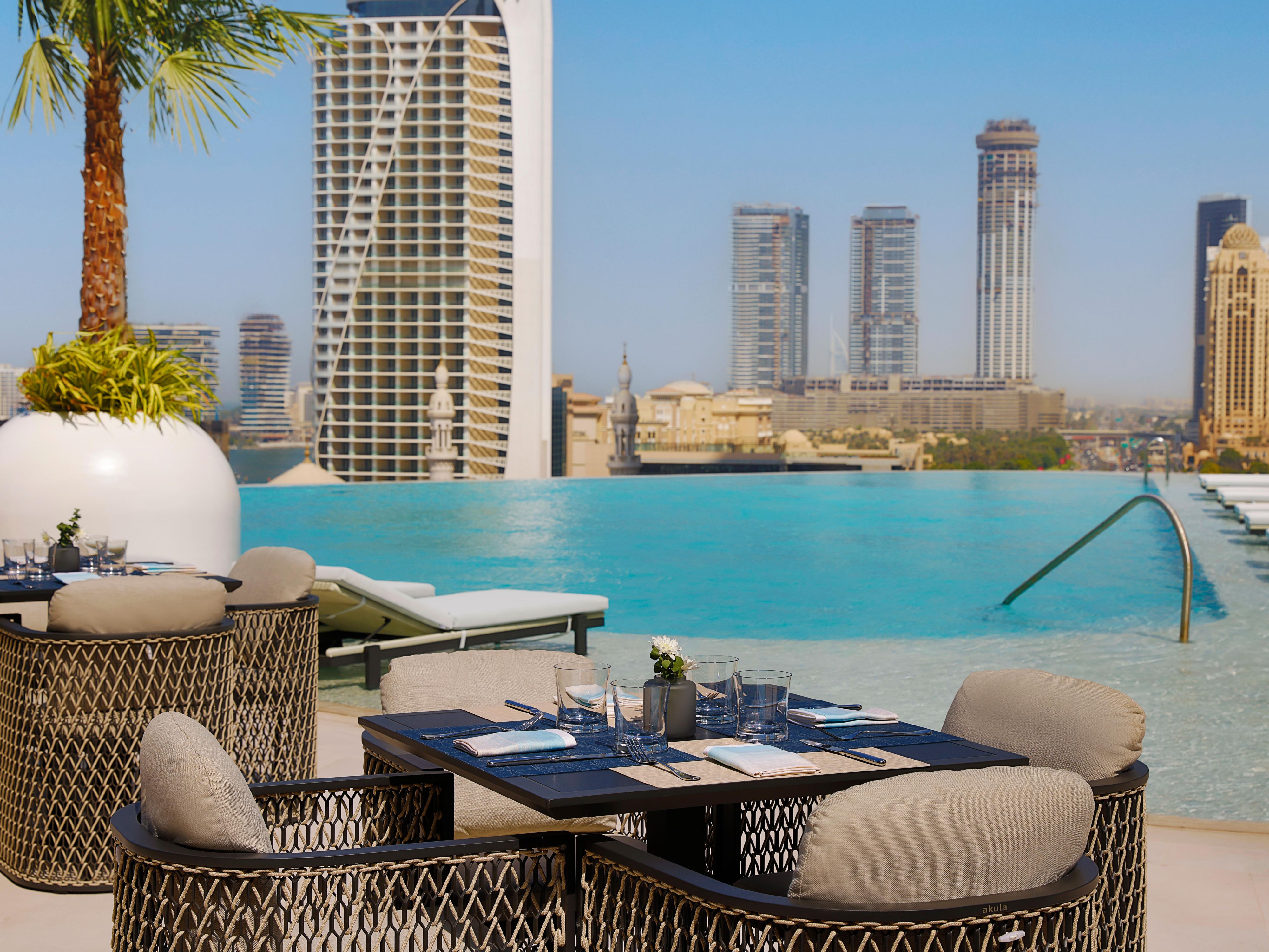 Tables beside the pool invite lingering moments
