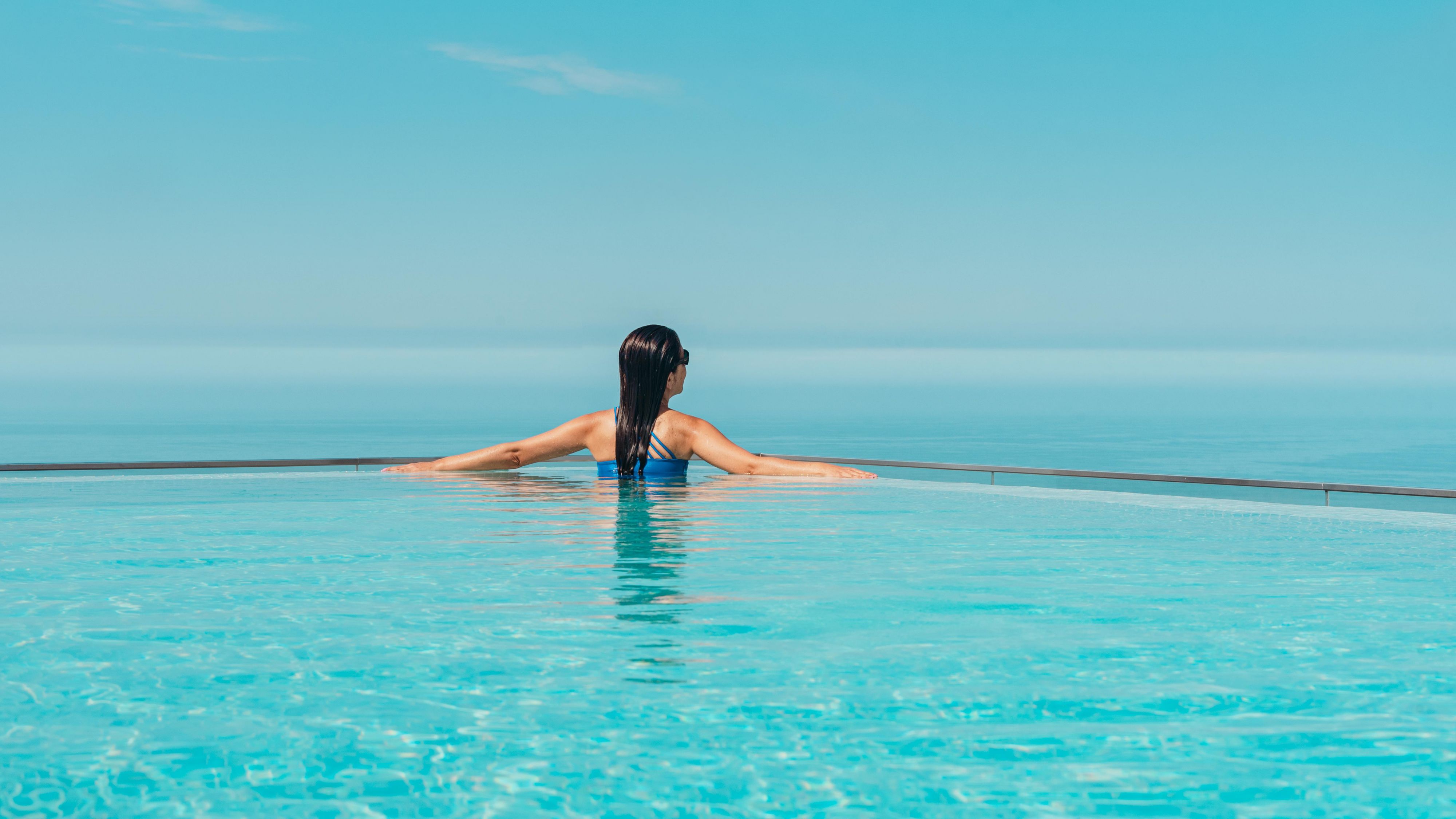 Guesting enjoying the infinity pool while looking out at the ocean