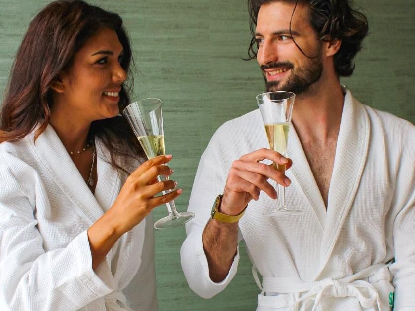 Couple in spa robes enjoying a glass of champagne