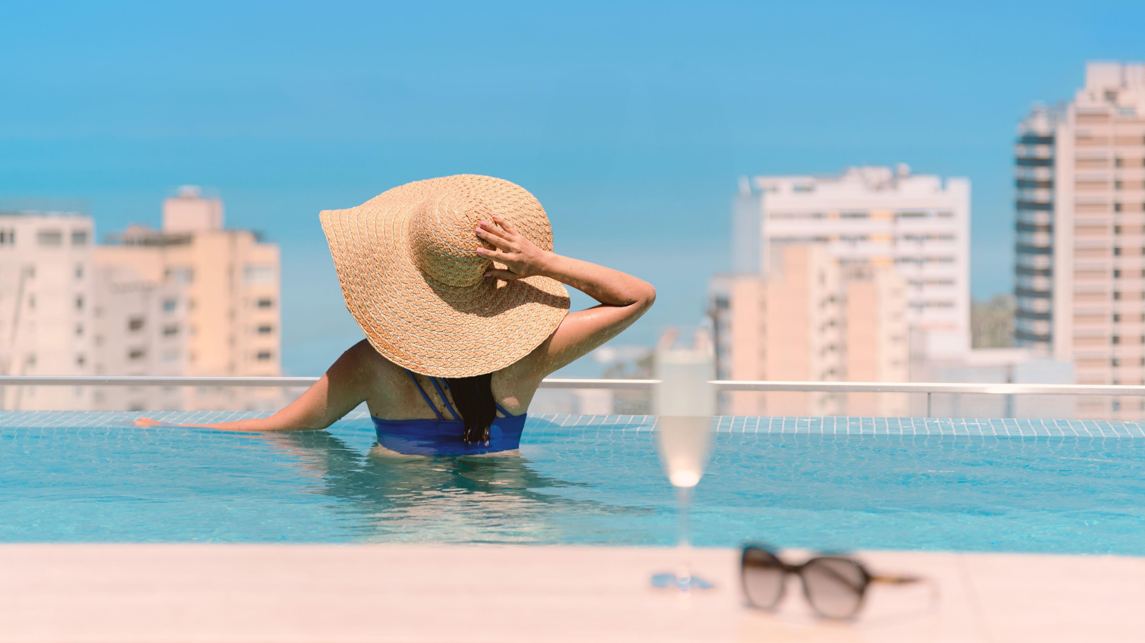 Guest enjoying the rooftop pool with views of the city