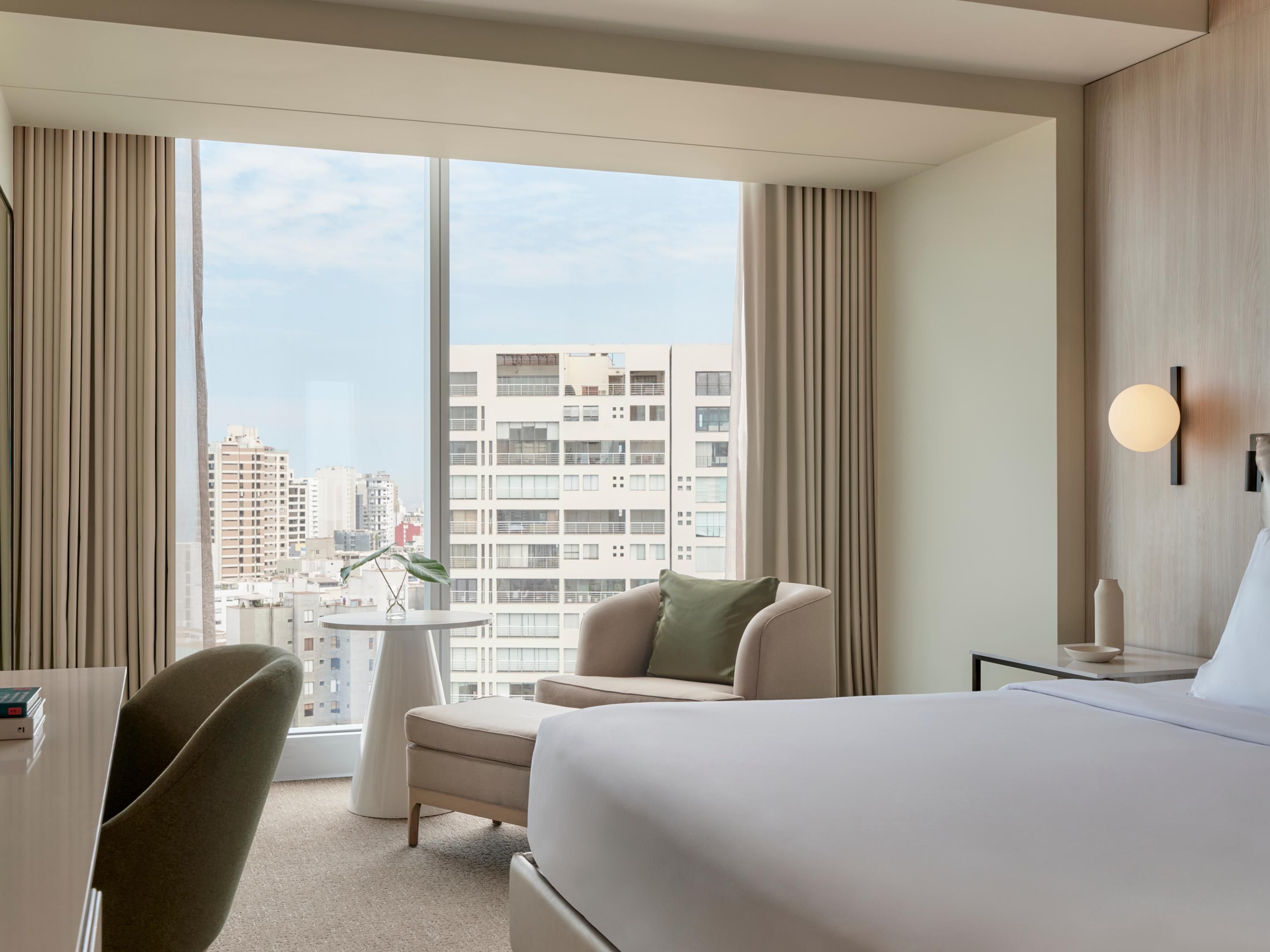 Hotel room with a king-sized bed and a view of the city
