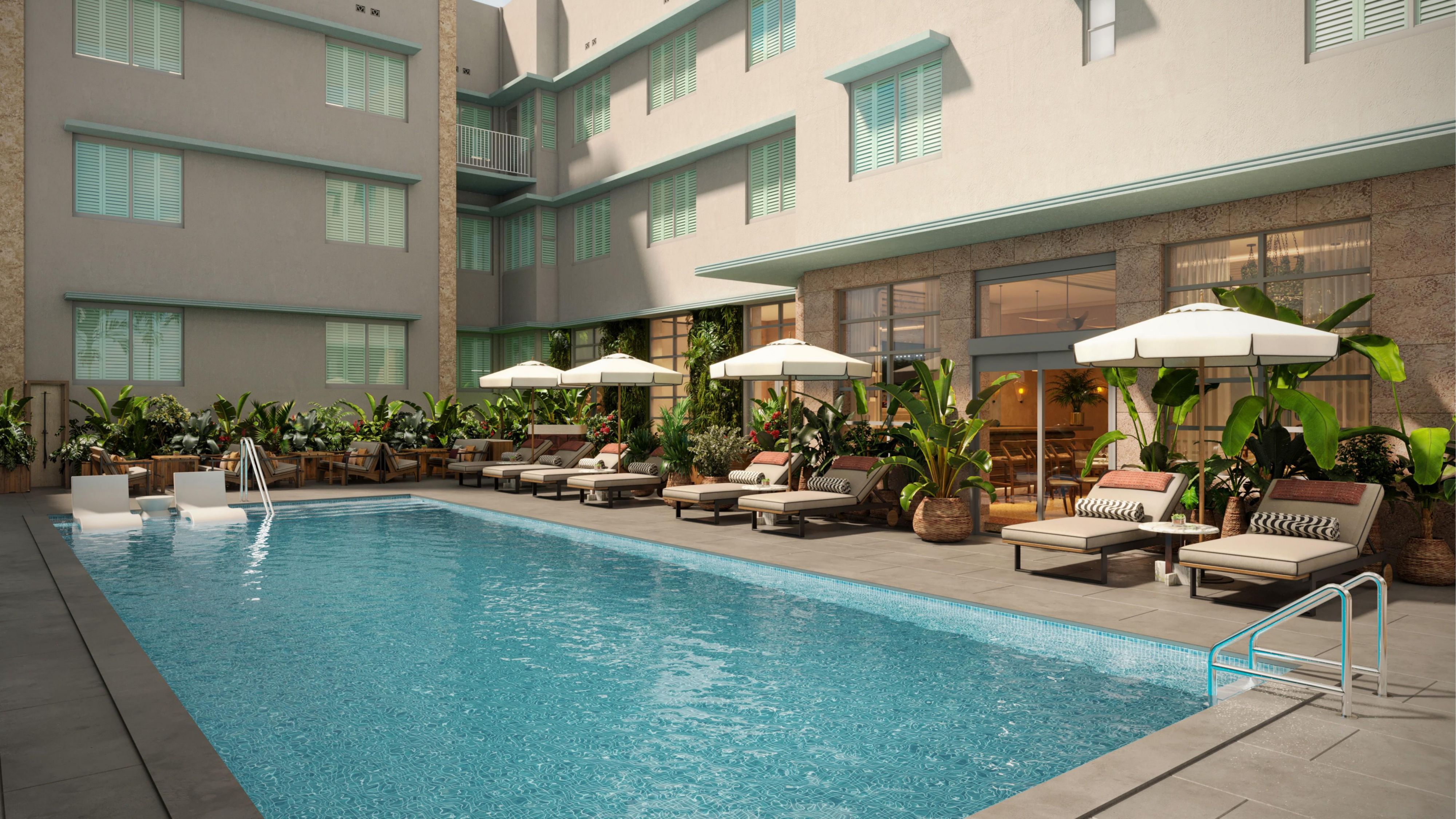 Sunny courtyard pool with chaise loungers in Miami Beach.