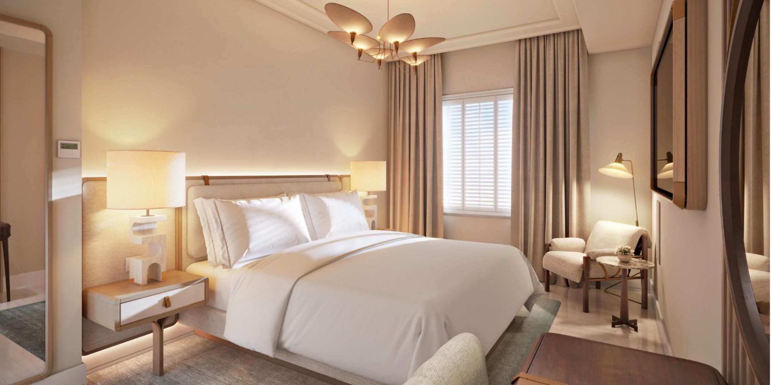 A king bed sits beneath an organic brass light near the window.