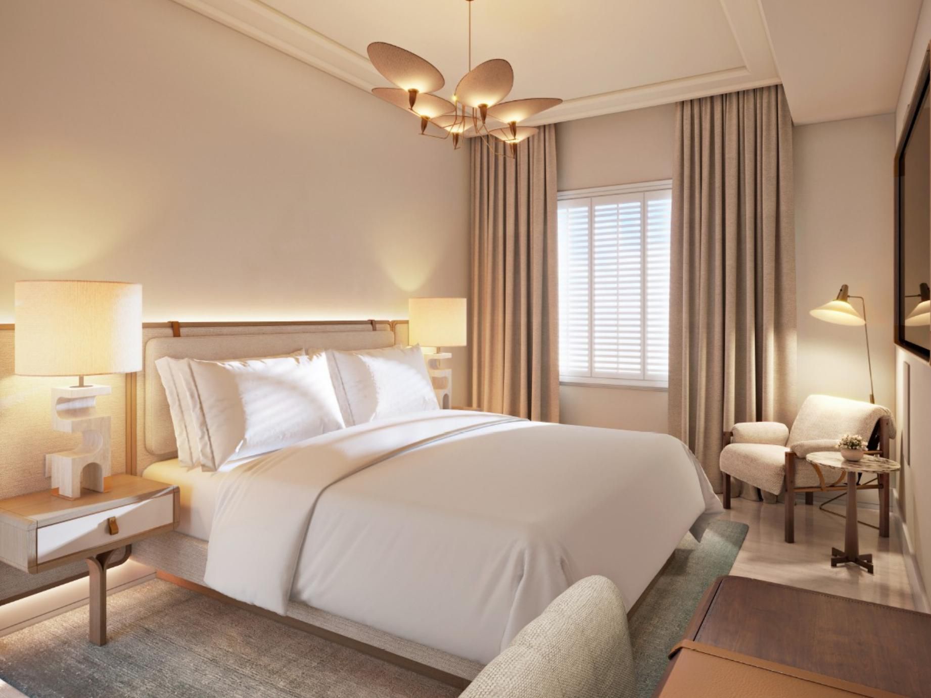 A king bed sits beneath an organic brass light near the window.