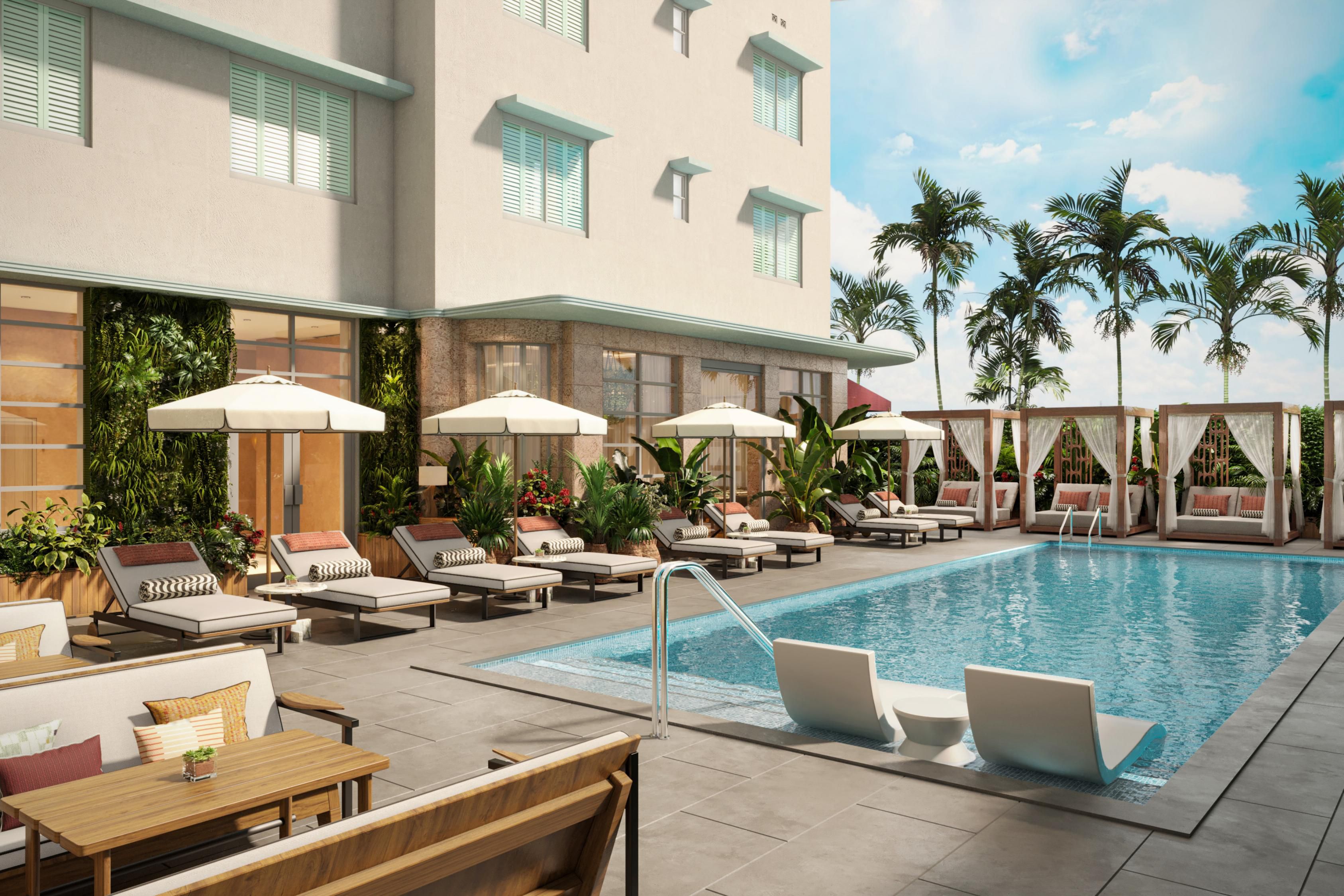 Our turquoise pool fringed by cream loungers, cabanas, and palms.