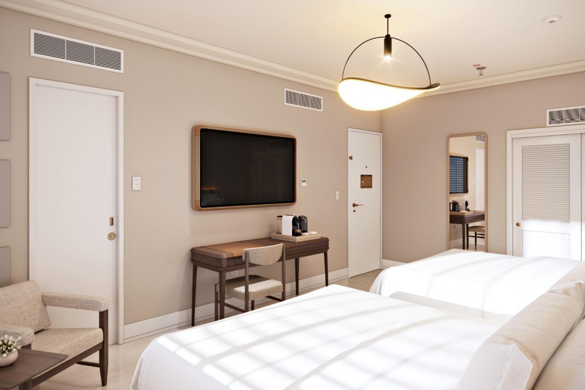 Stay in our double queen room with two white beds and soft dayligh