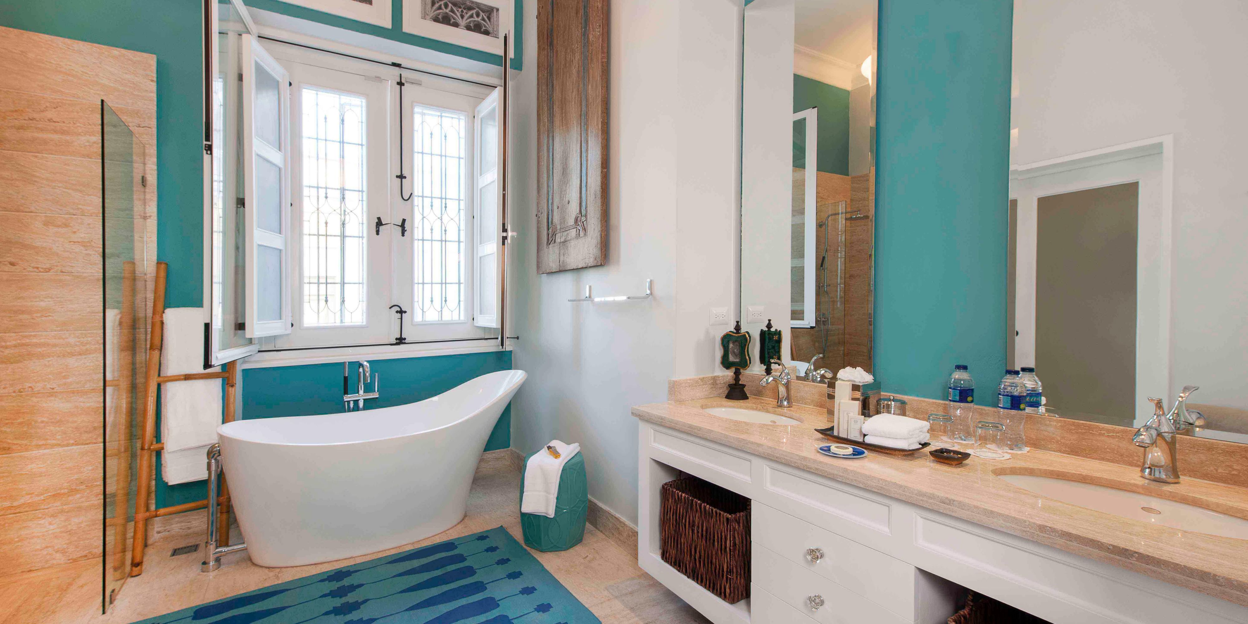 Bright bathroom with modern tub and turquoise decor.