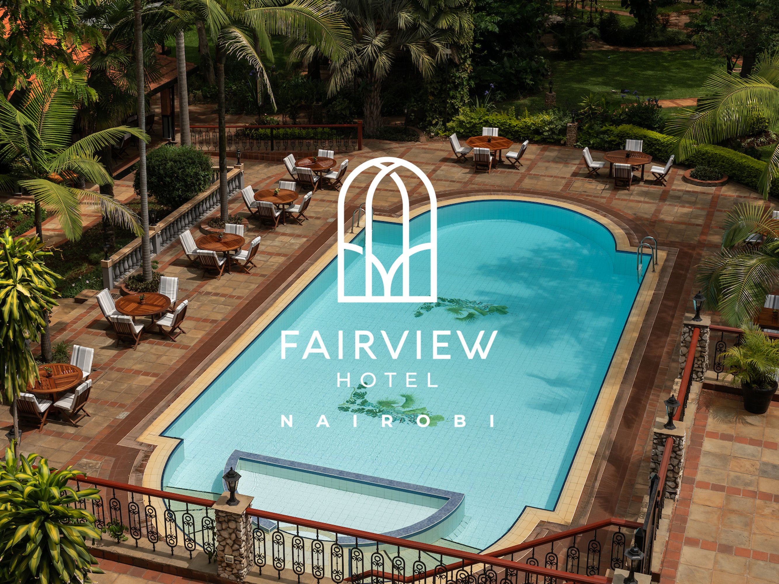 Outdoor pool of Fairview Hotel Nairobi with seating and palm trees.