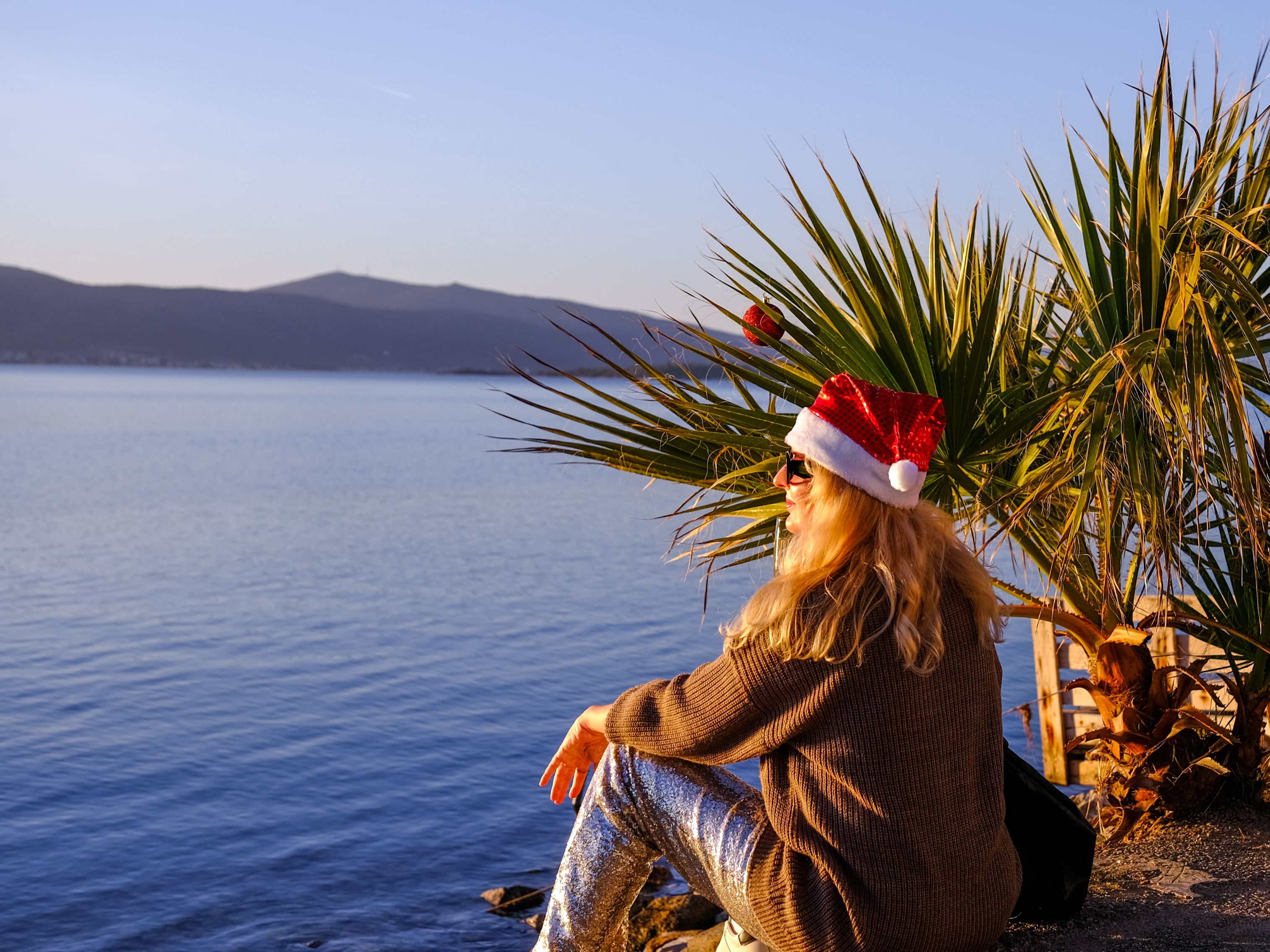 woman on beach wearing Santa hat