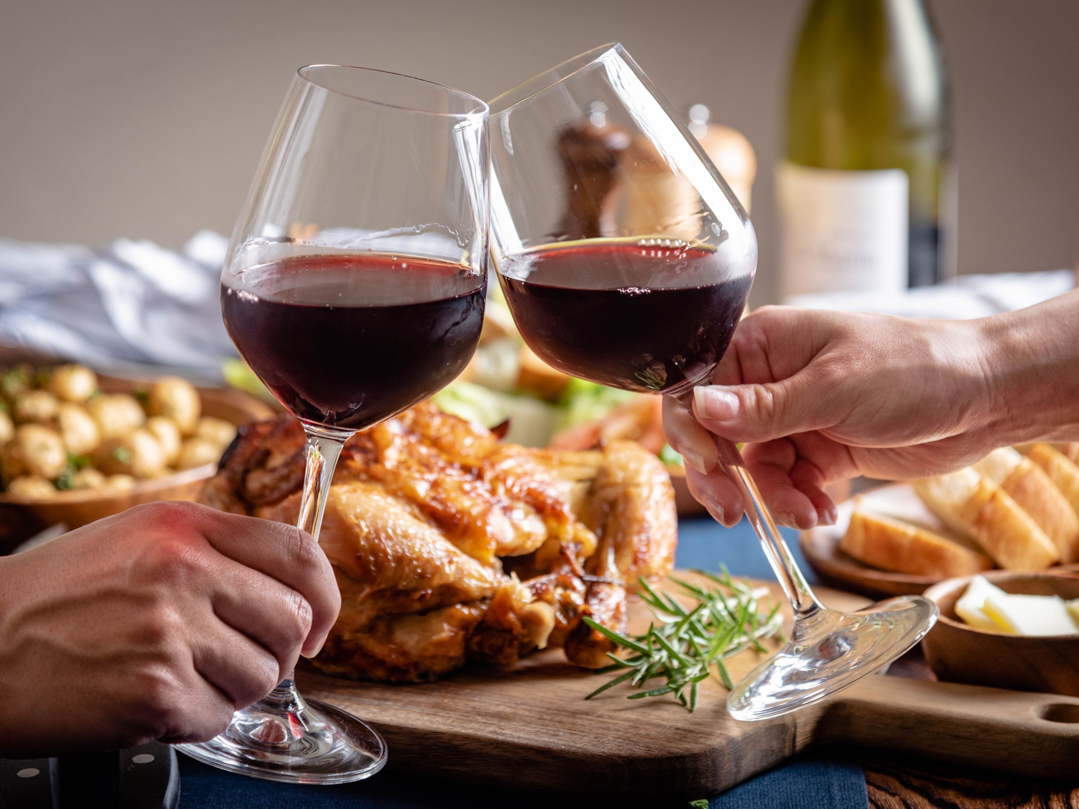 Cheers with wine glasses over Thanksgiving dinner