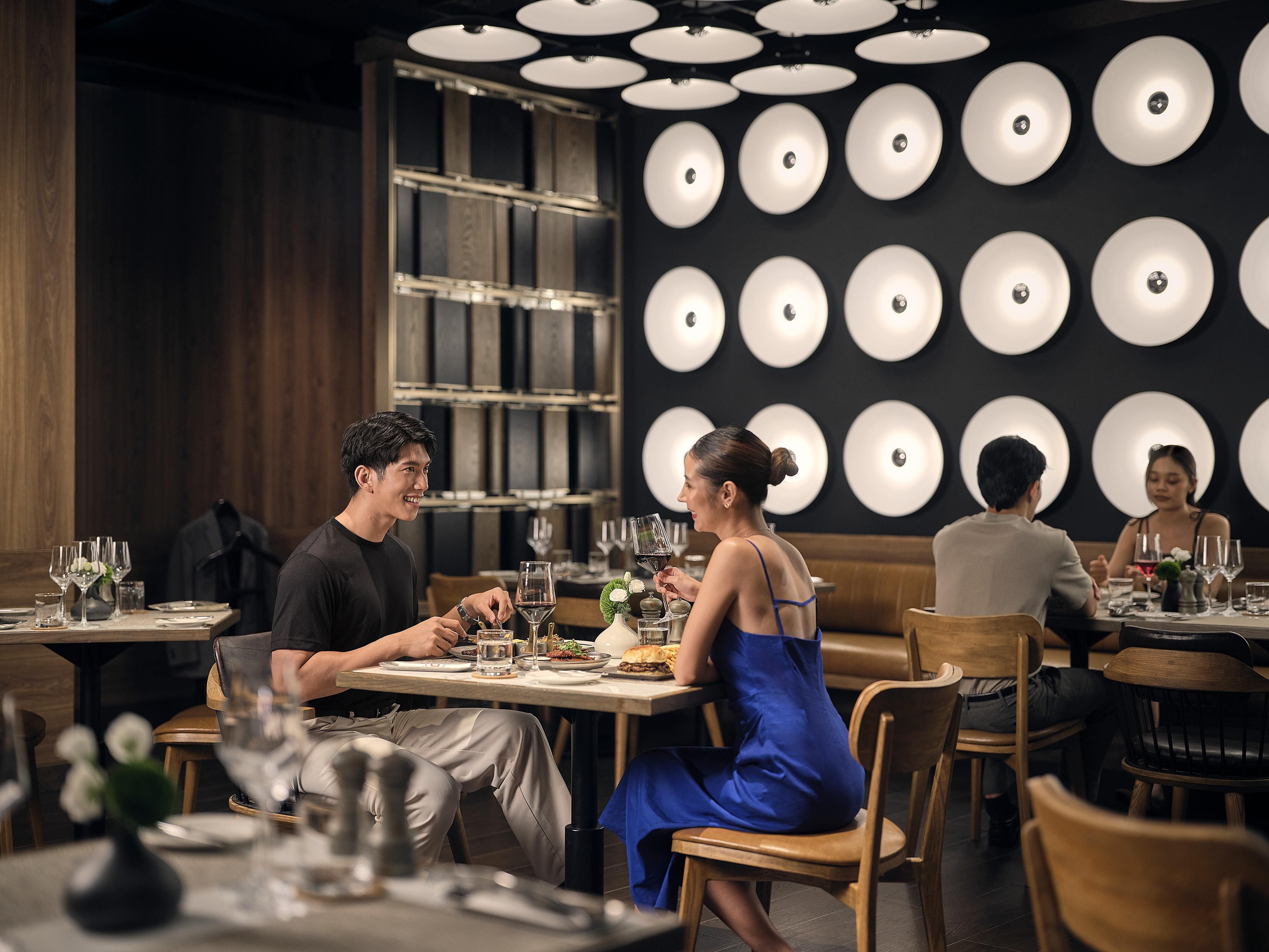 Modern restaurant interior with elegant seating and distinctive circular wall lighting.
