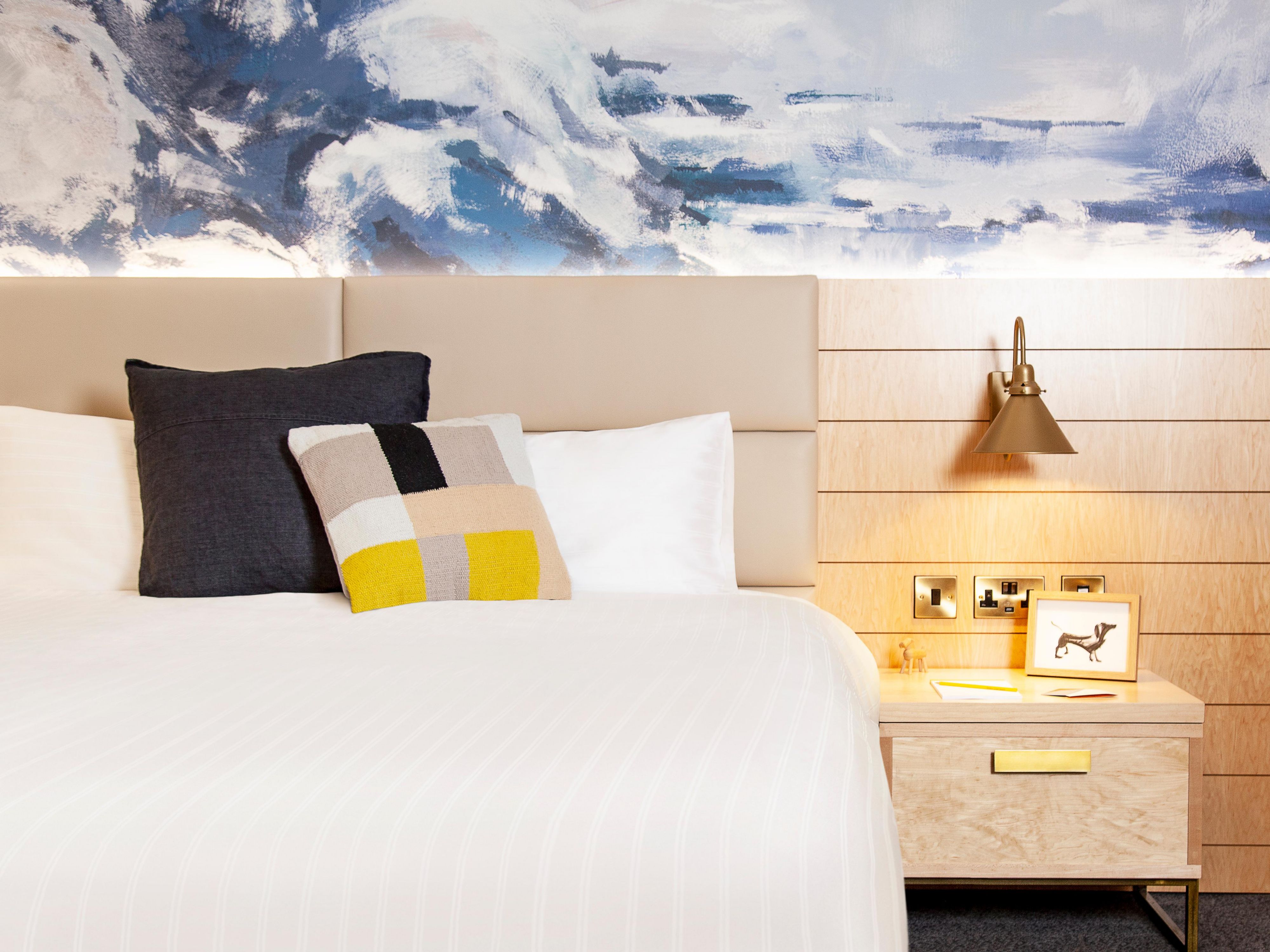 A cozy bed with artistic pillows