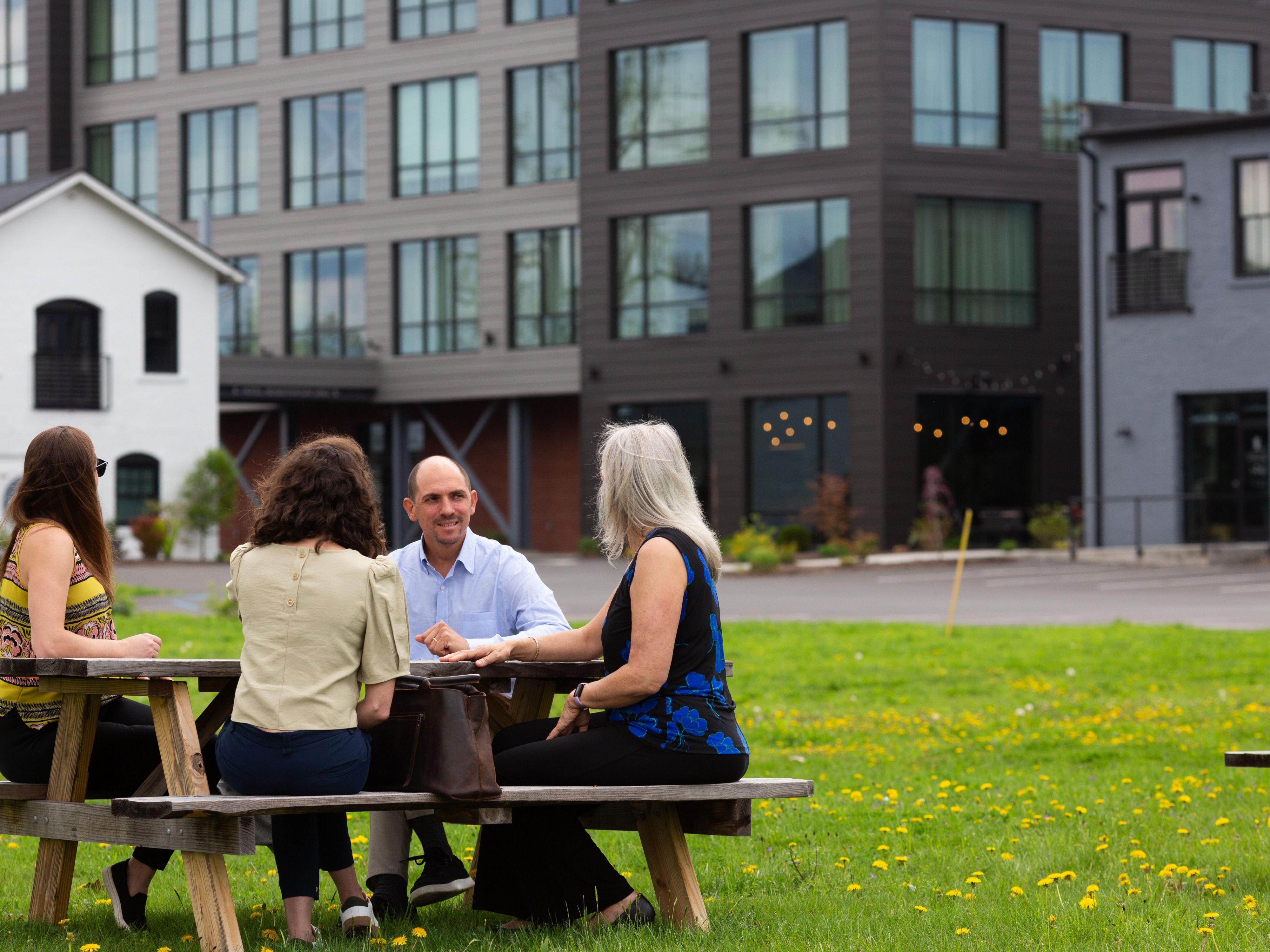 Guests sitting at picnic table outside of hotel
