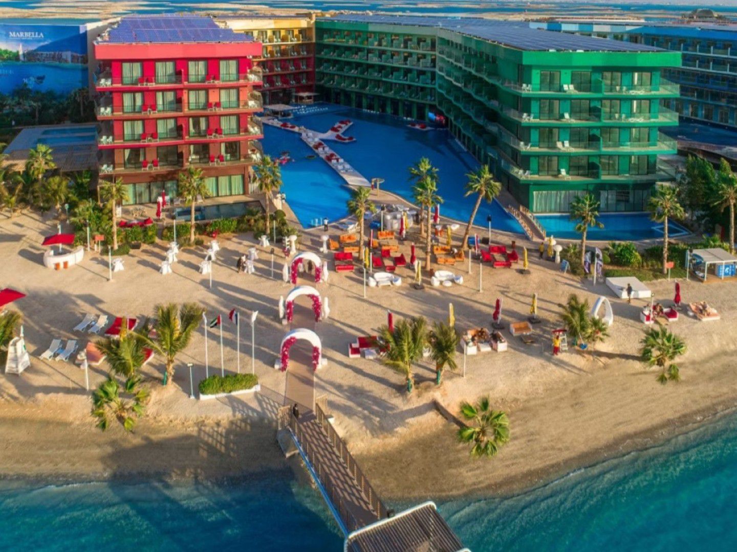 Панорамный вид на отель, бассейны, пляж и пирс voco Dubai Nice.