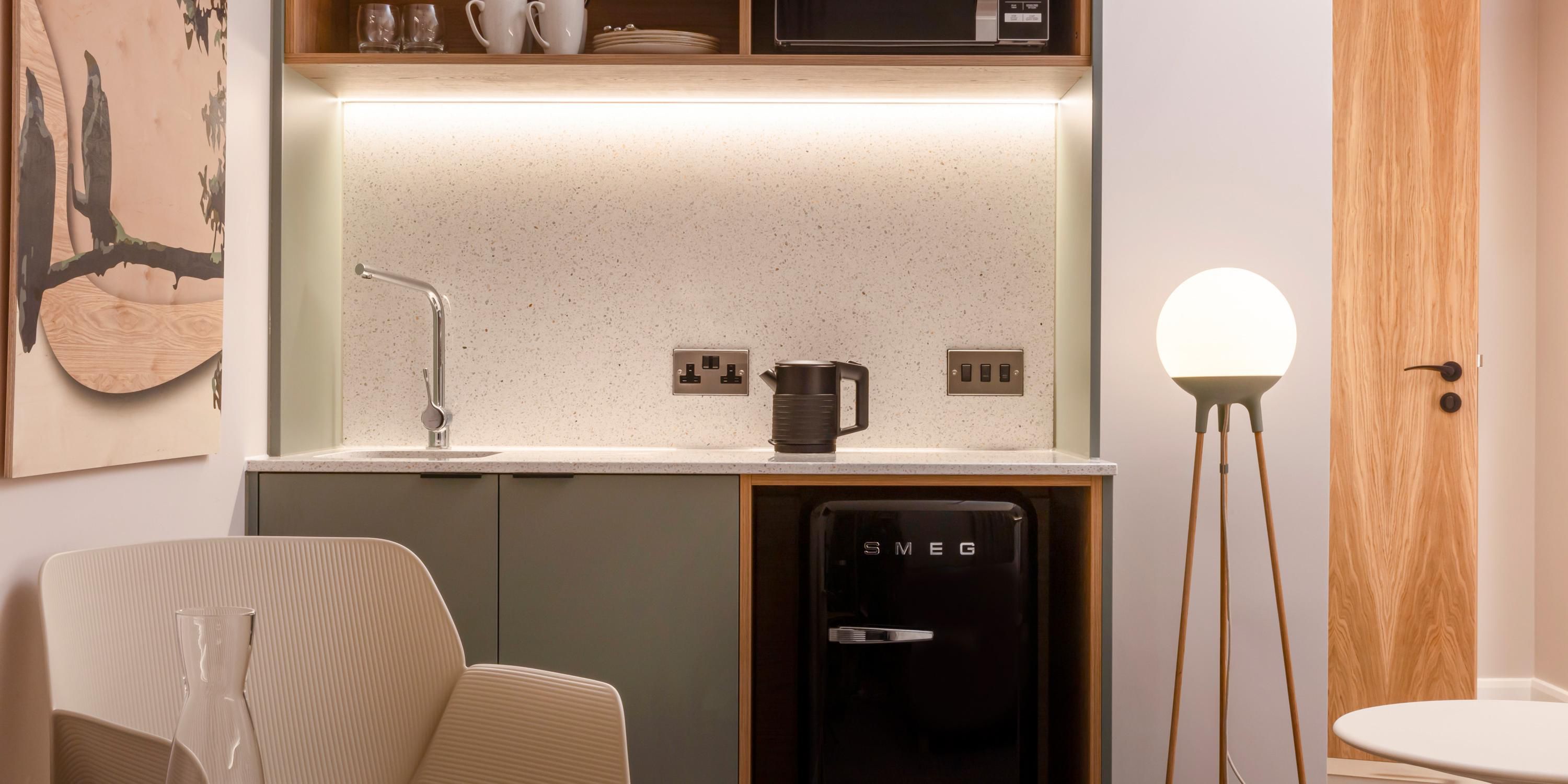 This stylish kitchenette room, complete with a single sofa bed, is perfect for guests planning a longer stay . The modern design includes a compact SMEG fridge, microwave, kettle, and ample shelving, allowing guests to enjoy home comforts. Comfortable seating and soft lighting create a comfy, functional space for both rest and productivity. 