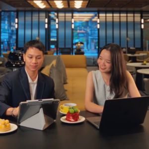 Two people dining together at a restaurant table with laptops.