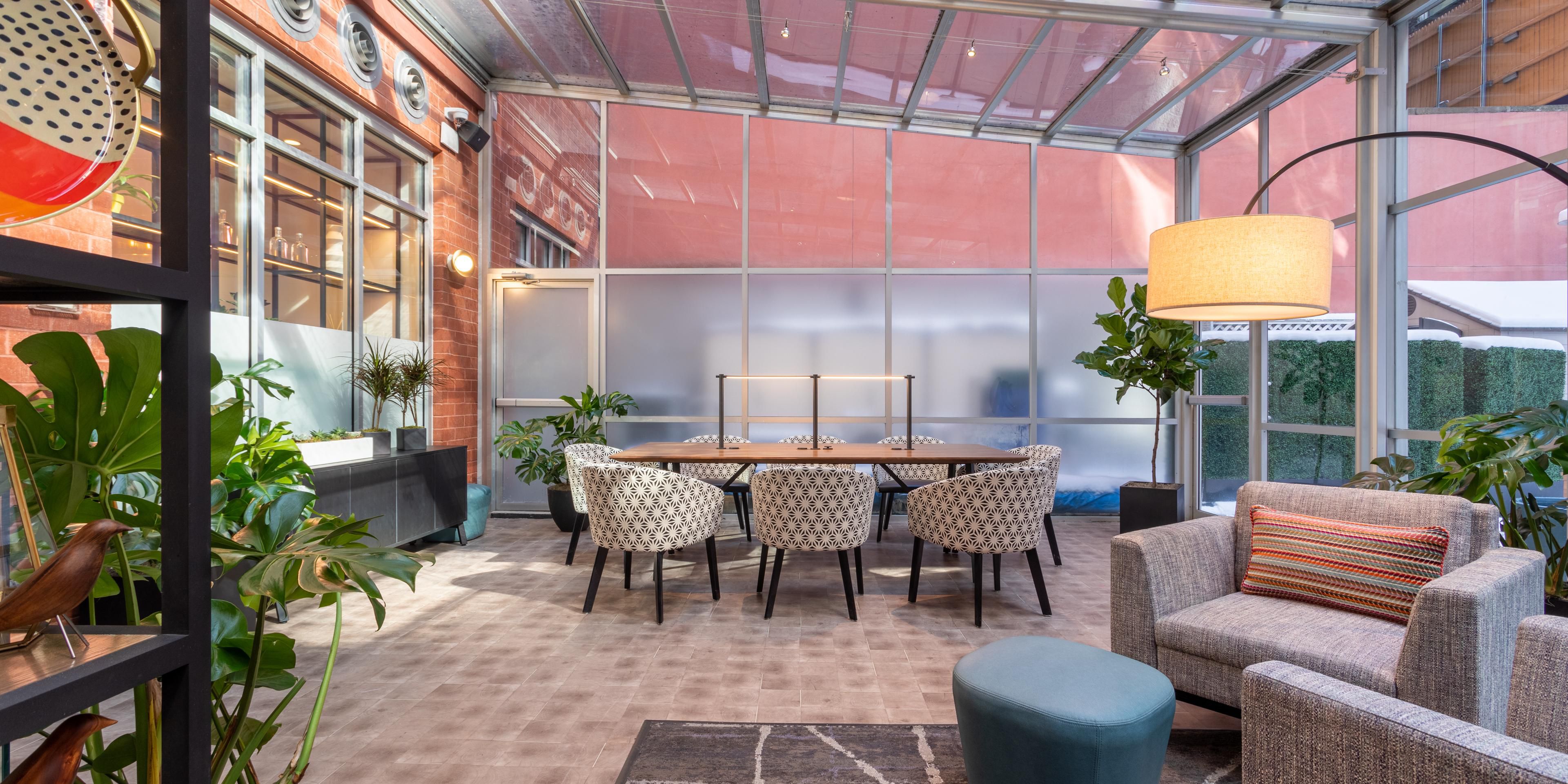Guests enjoy the greenhouse, with cozy nooks and communal tables.