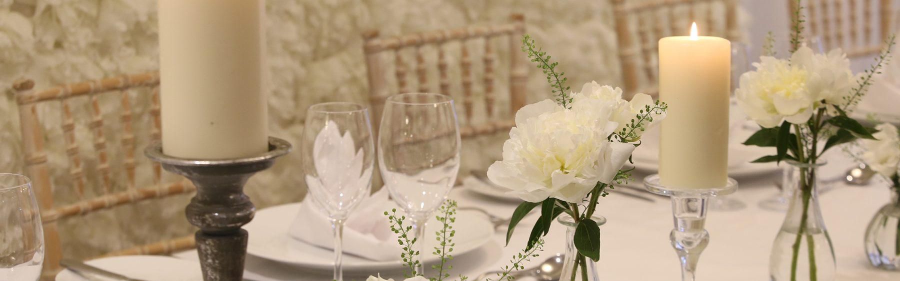 Candles and flowers on a white cloth table