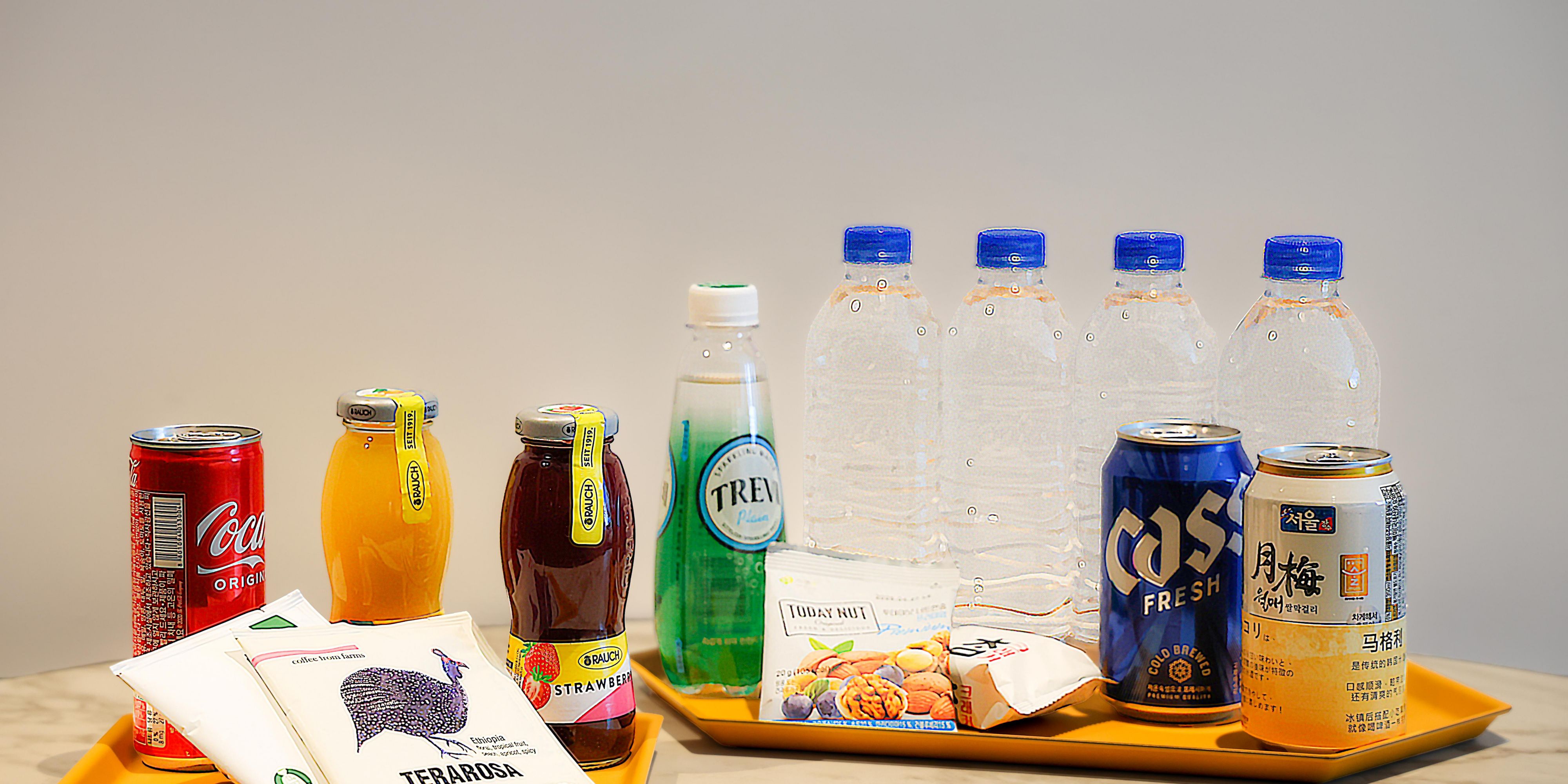 Enjoy a complimentary in-room minibar featuring two juices (orange, strawberry), two canned alcoholic drinks (makgeolli, beer), Coca-Cola, sparkling water, four bottles of mineral water, a premium tea set with Terarosa drip coffee and Swiss Miss cocoa, plus assorted snacks like daily nuts and crackers.