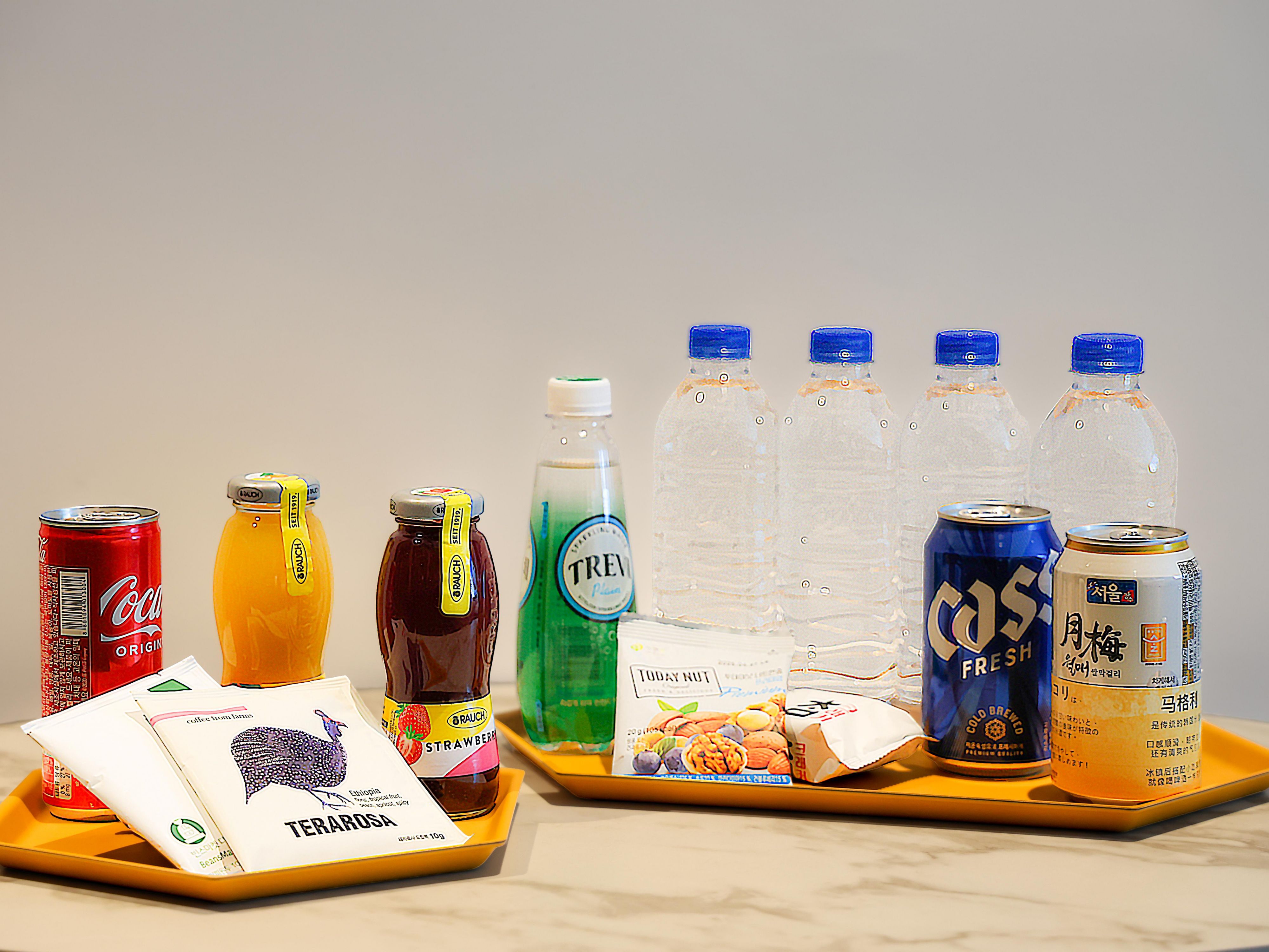 Enjoy a complimentary in-room minibar featuring two juices (orange, strawberry), two canned alcoholic drinks (makgeolli, beer), Coca-Cola, sparkling water, four bottles of mineral water, a premium tea set with Terarosa drip coffee and Swiss Miss cocoa, plus assorted snacks like daily nuts and crackers.