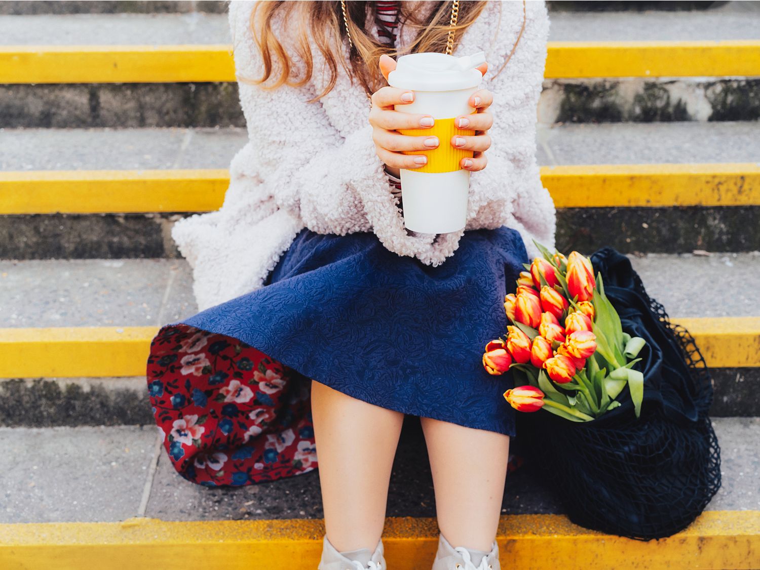 Lady on steps with coffee and flowers