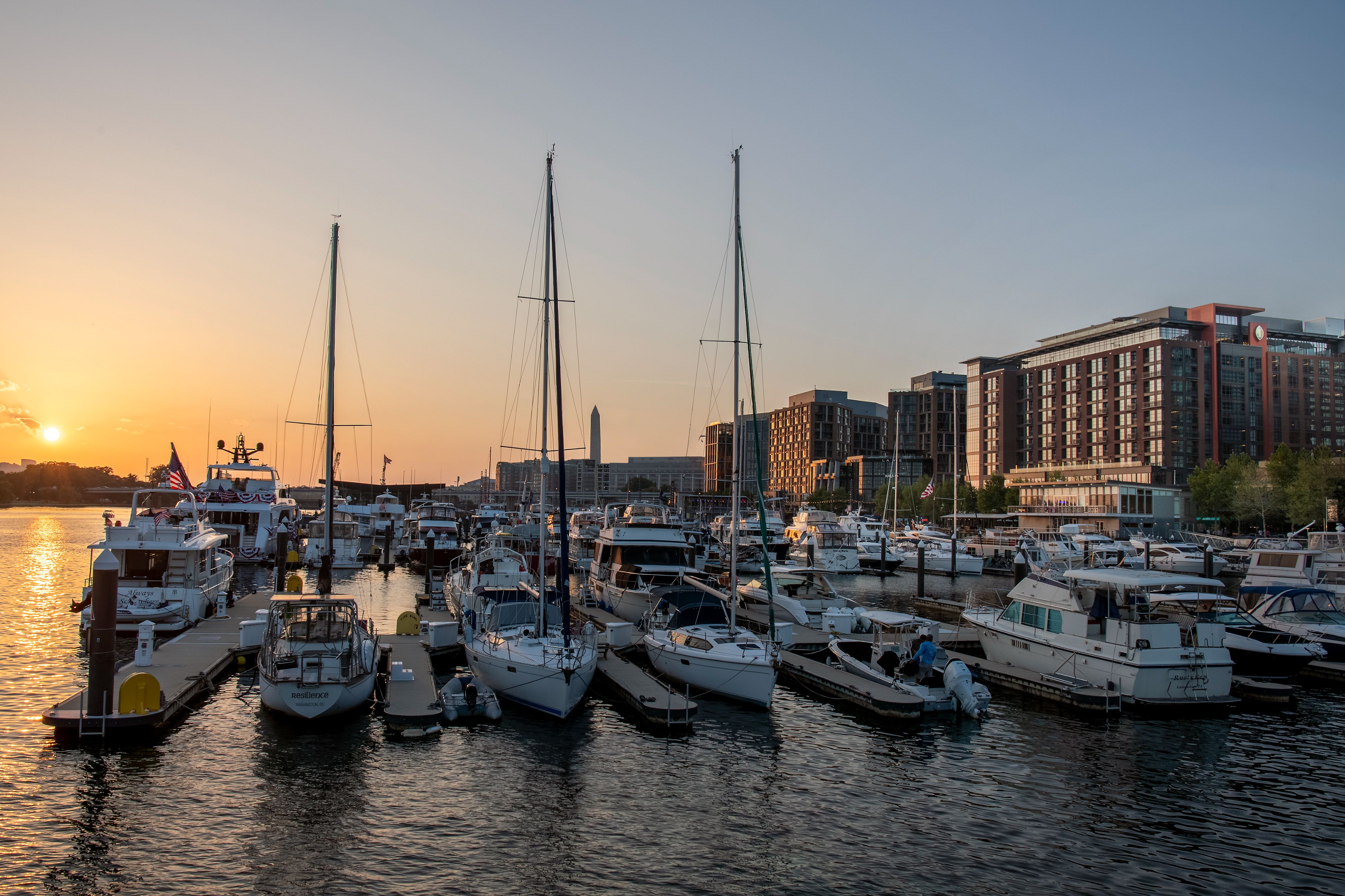 Boats docked at The Wharf marina at sunset, with IC The Wharf behind it.