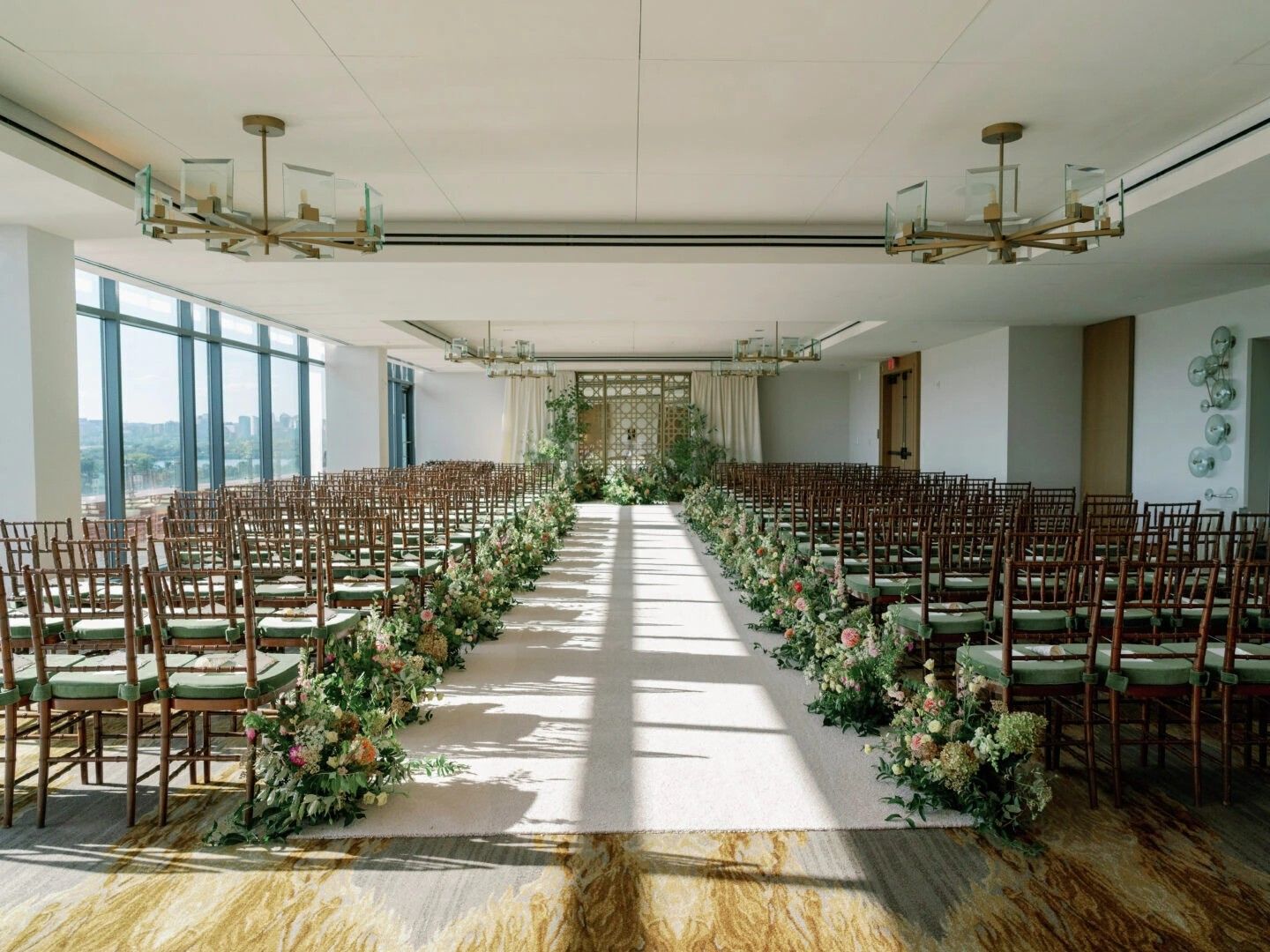 Ballroom set up for wedding ceremony with chairs, aisle and decor