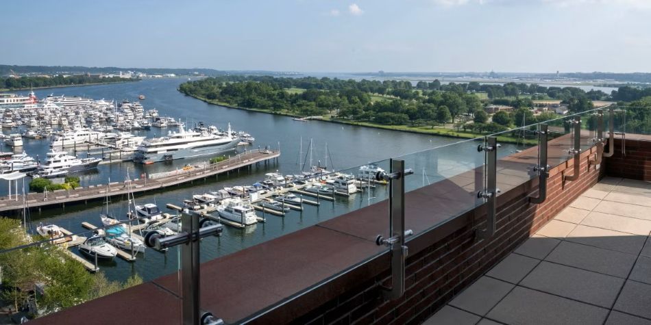 Constellation Suite balcony with glass railings and panoramic marina and river views.