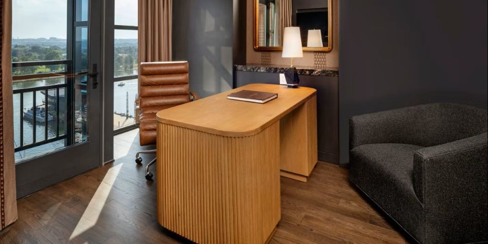 Constellation Suite office area with light-wood desk, leather chair, and waterfront views.