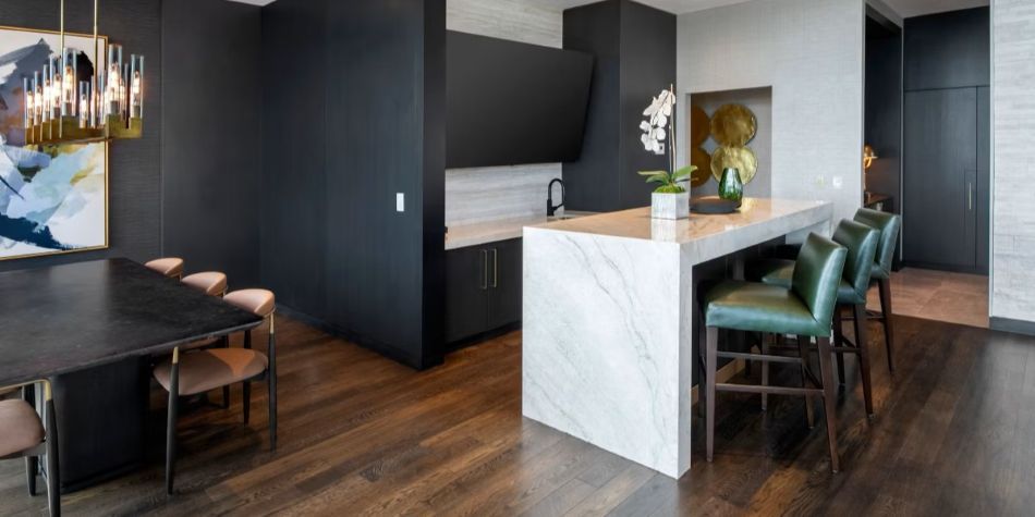 Constellation Suite dining area and kitchenette with marble bar, green barstools, and wet bar.