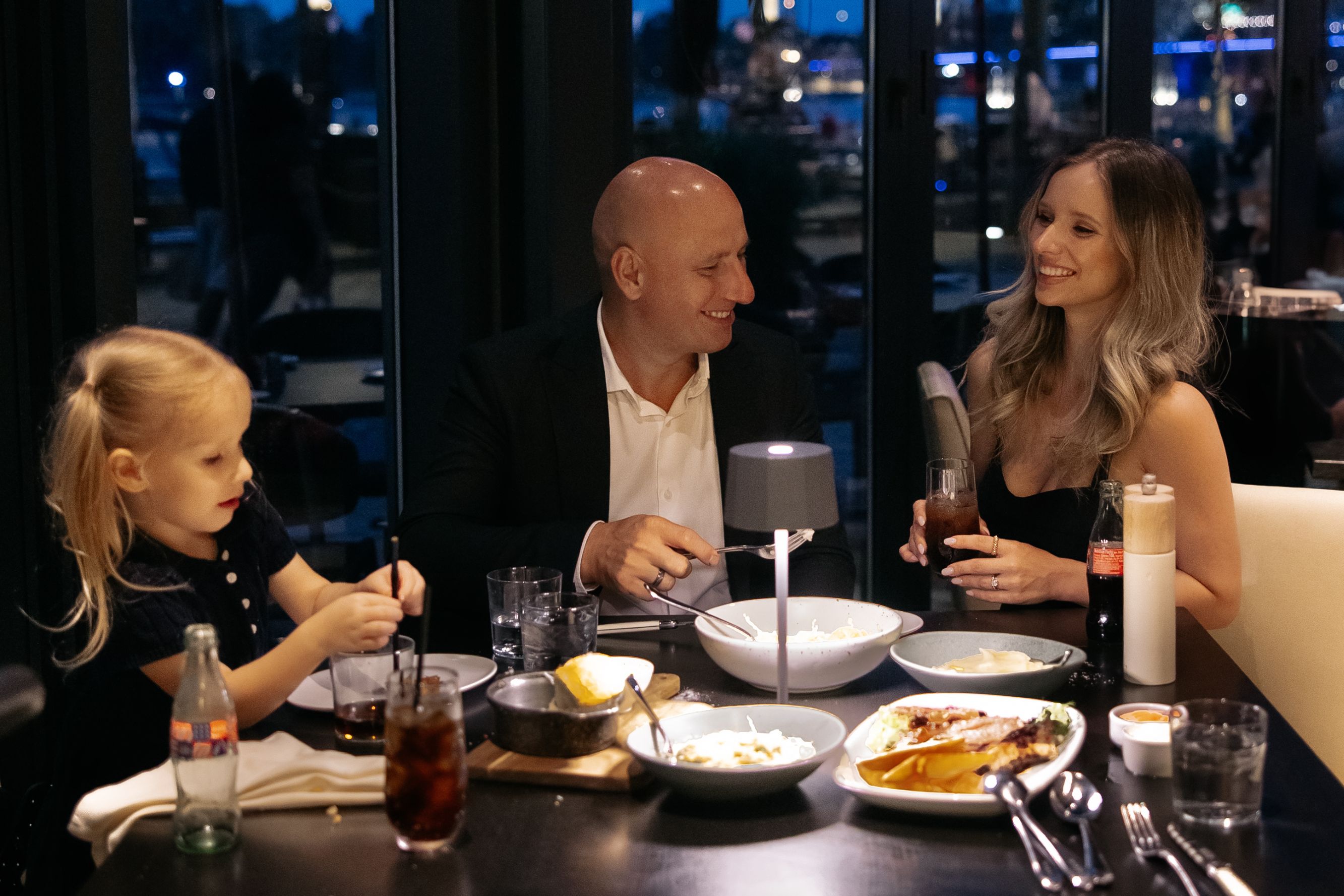 Family enjoying dinner at a Wharf waterfront restaurant.