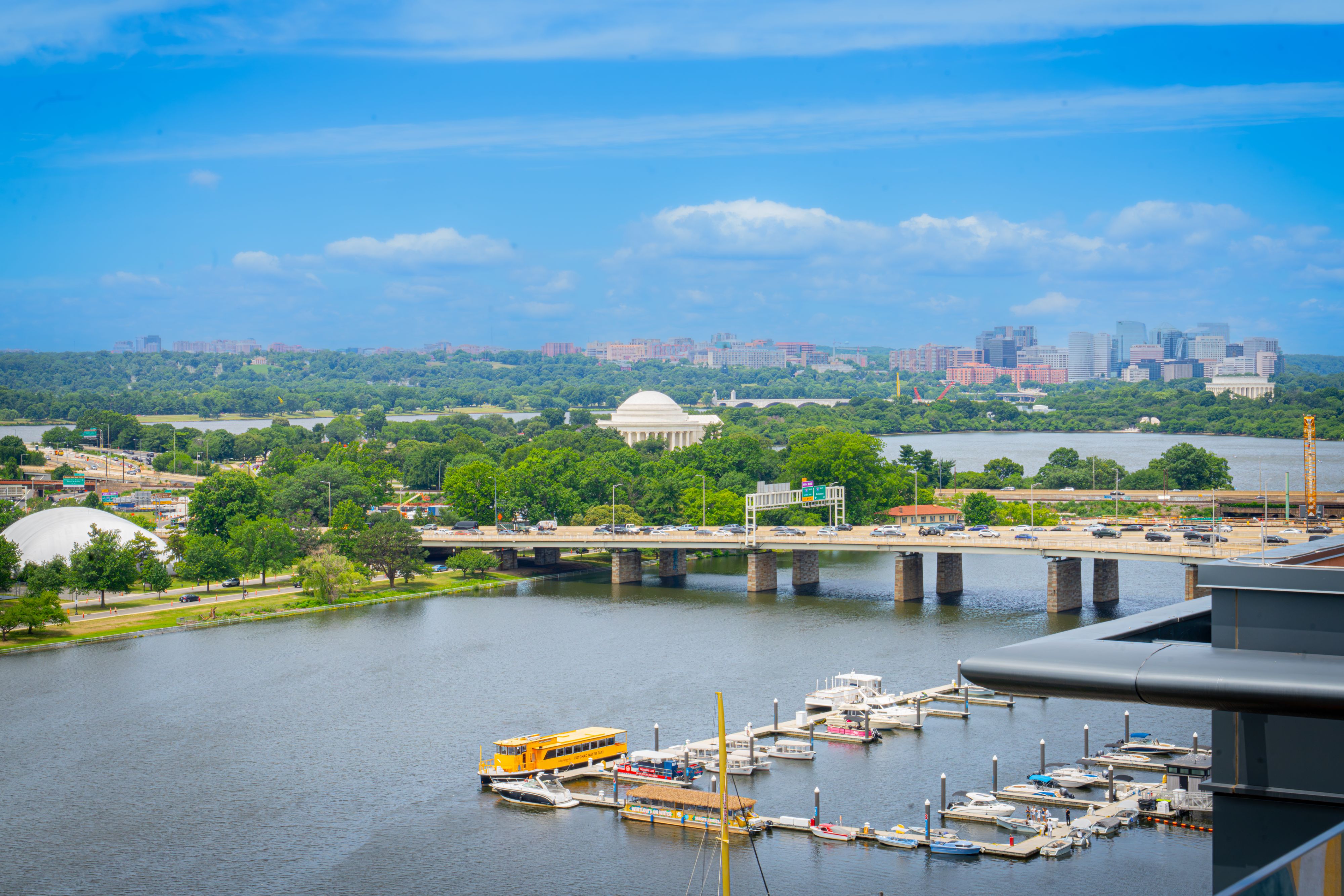 View of the Potomac River, marina, and Jefferson Memorial seen from The Wharf, with Washington, D.C. skyline and waterfront in the distance.