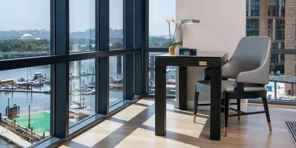 Workspace in front of floor to ceiling windows with wharf view.