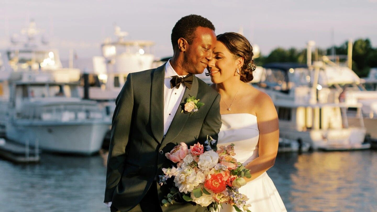 bride and groom standing in front of water