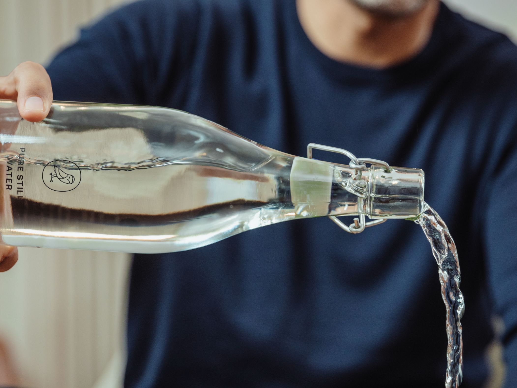Man pouring water into refillable cup.
