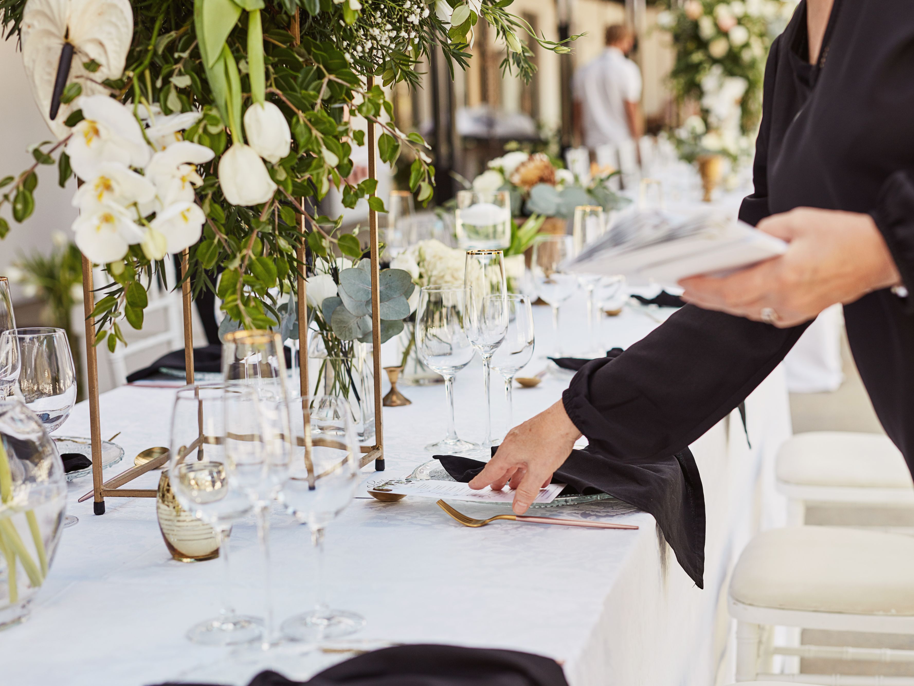 Elegant event table with floral centerpieces, glassware, and place settings prepared for a special gathering.