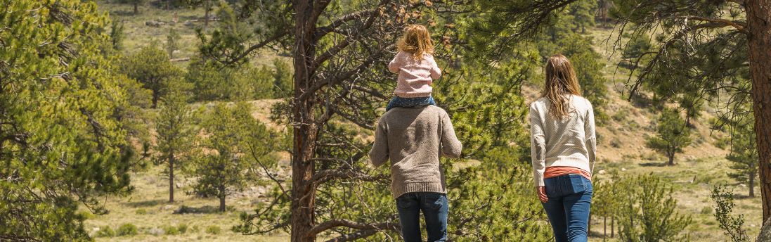 Family walking with daughter on dad's shoulders